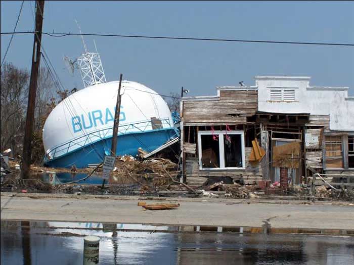 Post Hurricane Katrina photo. Fallen, elevated water tower and smashed building in Buras, Louisiana, where landfall occurred at 6:10 a.m. CDT on August 29, 2005. US EPA photo from "http://www.epa.gov/katrina/images/Slide9.jpg" by the United States.