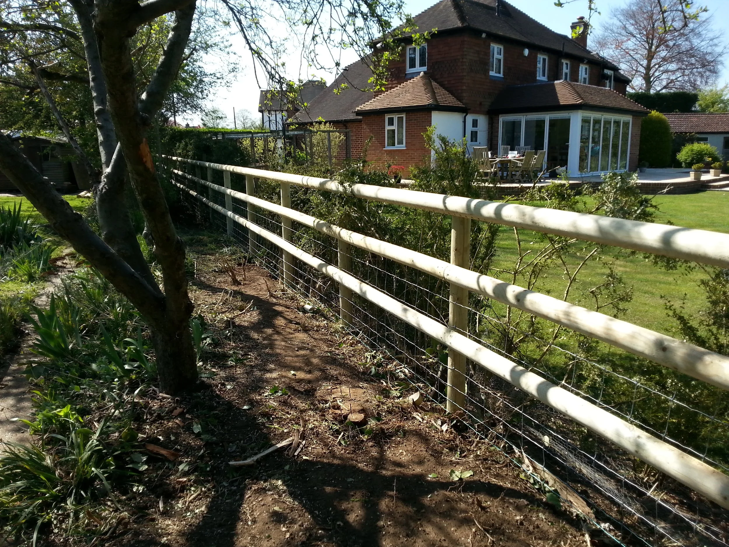High tensile strained stock fencing set on machine rounded post and rail, Cookham