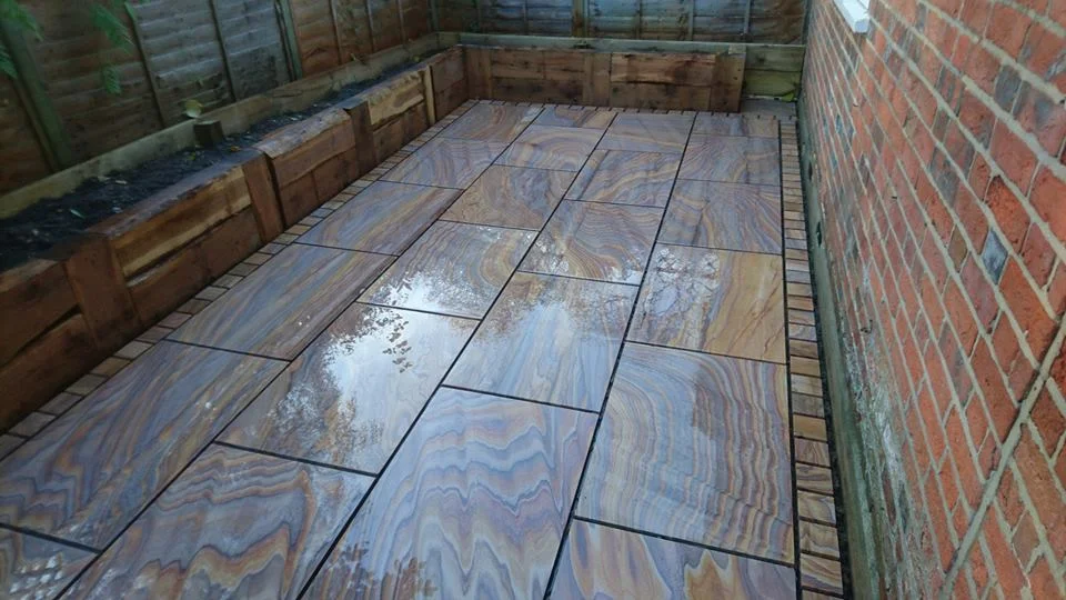 Machine cut rainbow sandstone patio edged with 100mm cobbles, Bisham