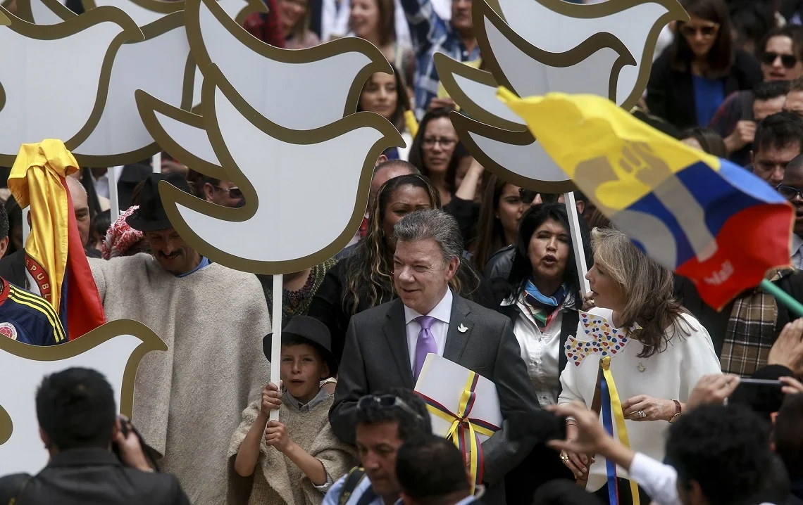 Colombian President, Juan Manuel Santos, holds a copy of the final text of the peace agreement with the FARC guerrillas