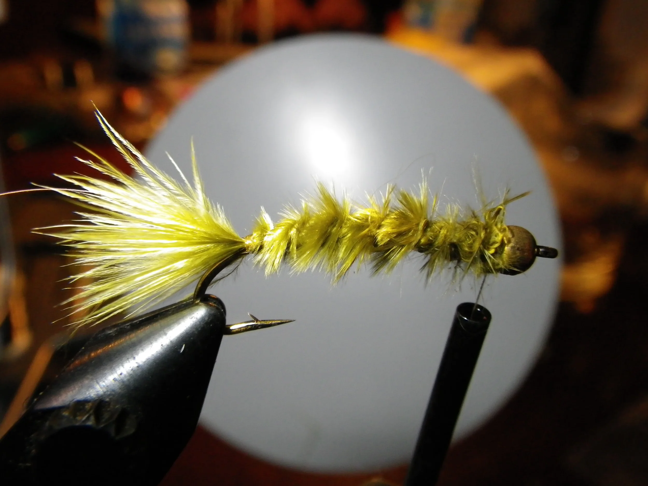 Wrap the waste end of the feather up the hook shank and tie off behind the bead