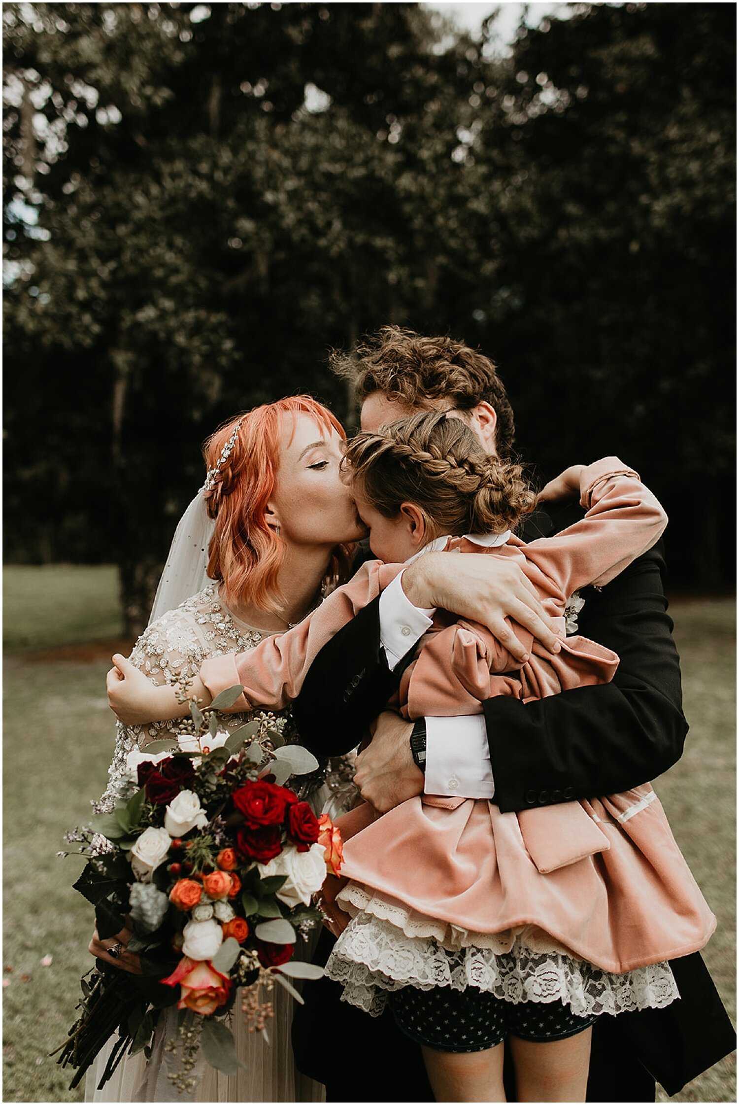  bride and groom kiss their daughter 