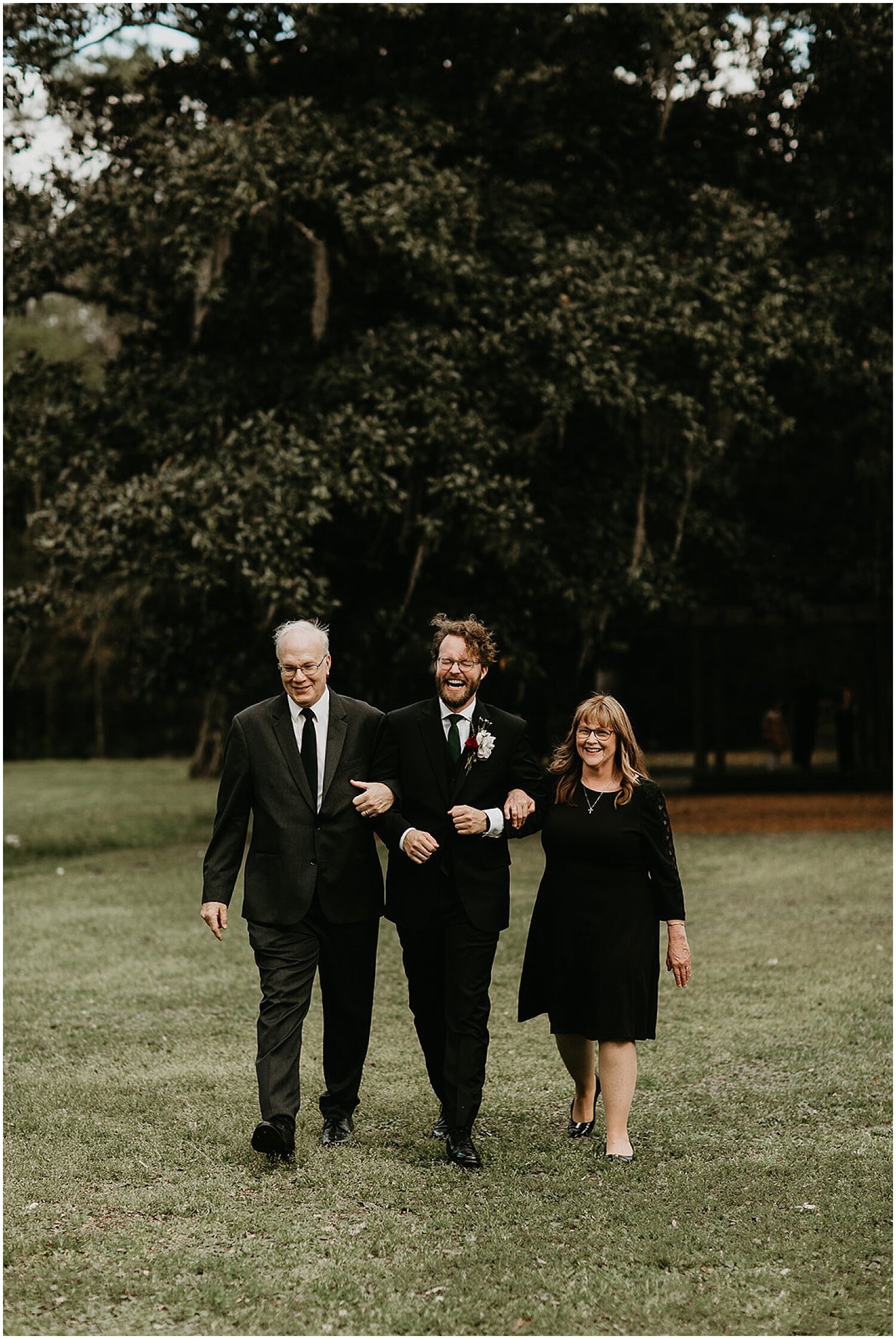  groom walking down the aisle with his parents 