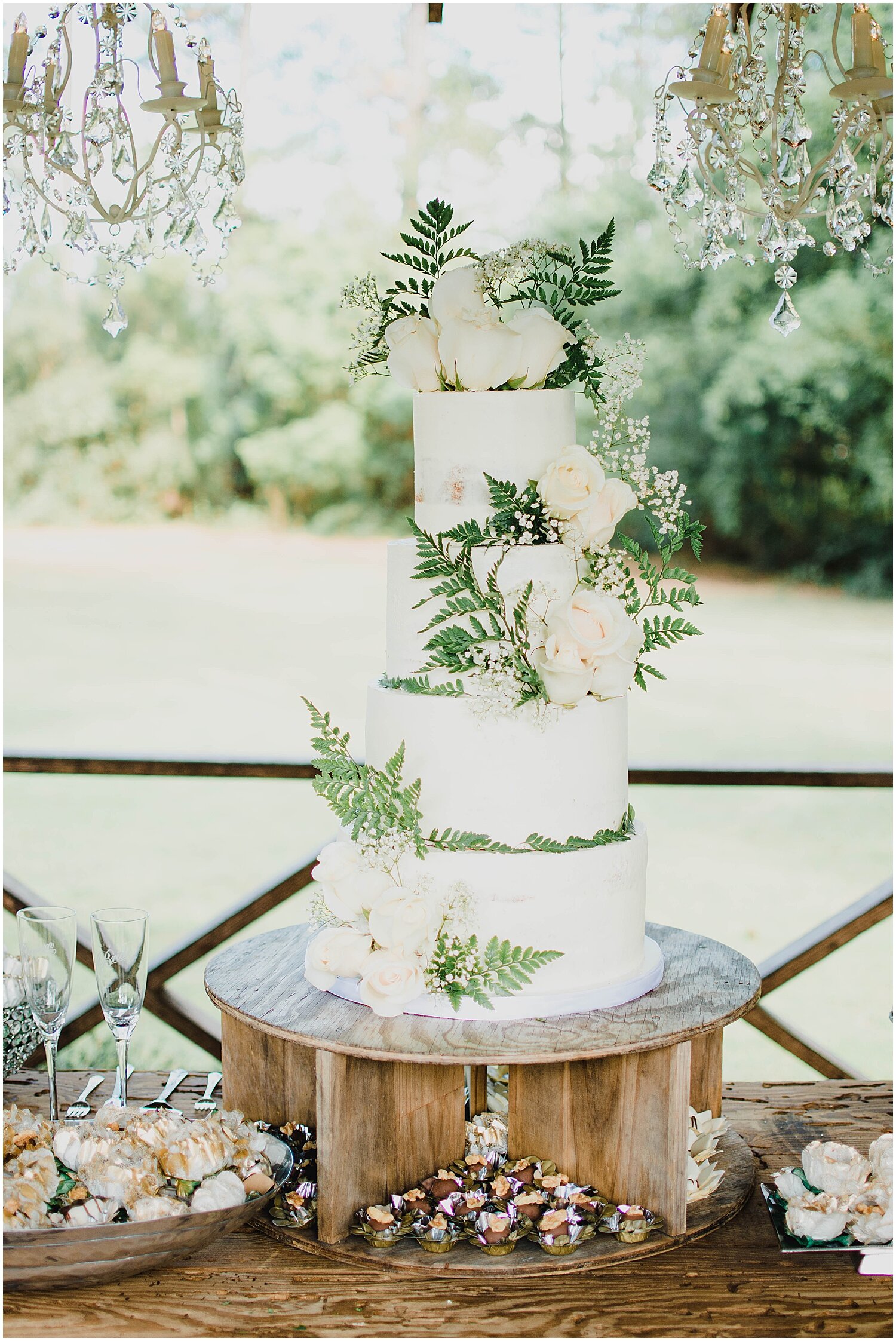  tall white wedding cake with floral and greenery decor 