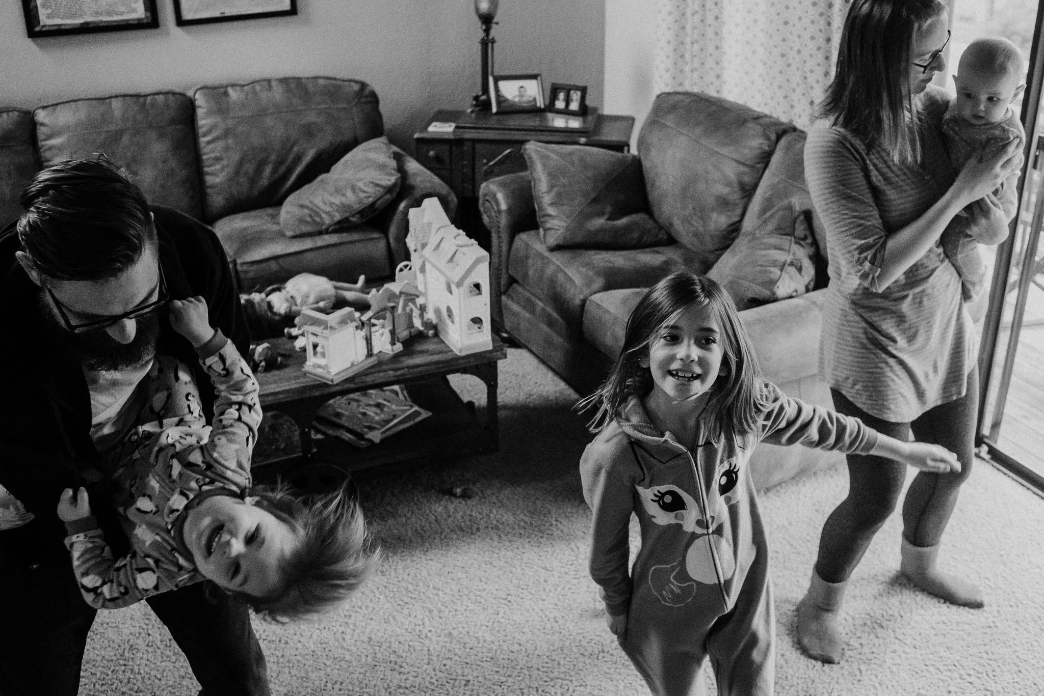 Family of five dancing in living room in their pajamas