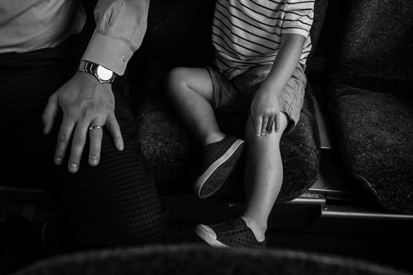 father and son sitting with hands on knee