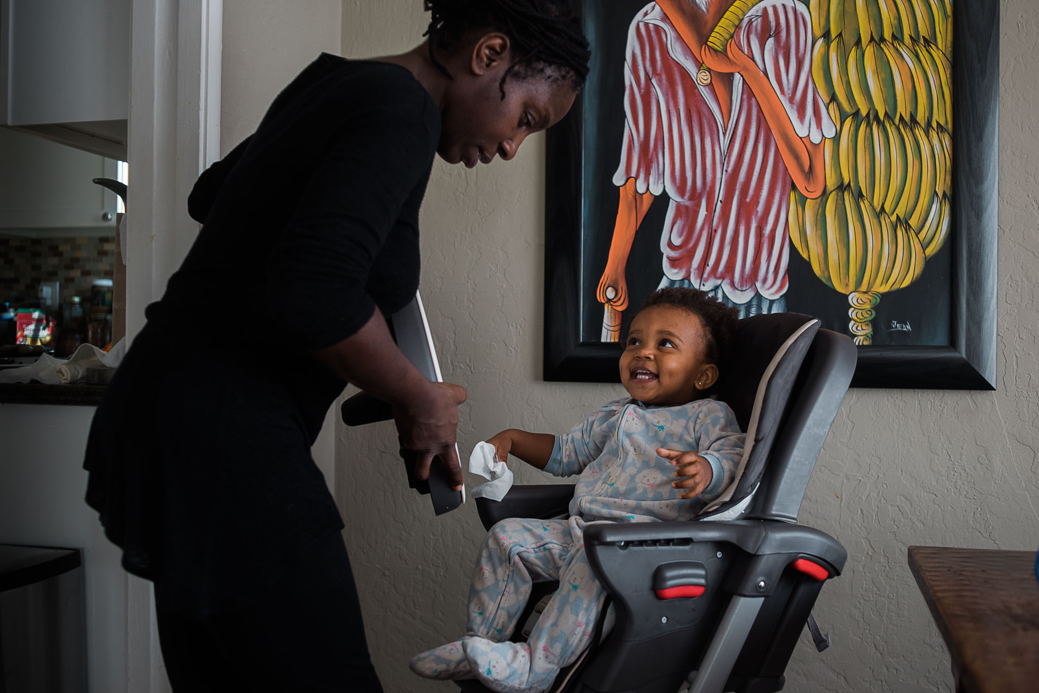mom helping daughter out of high chair