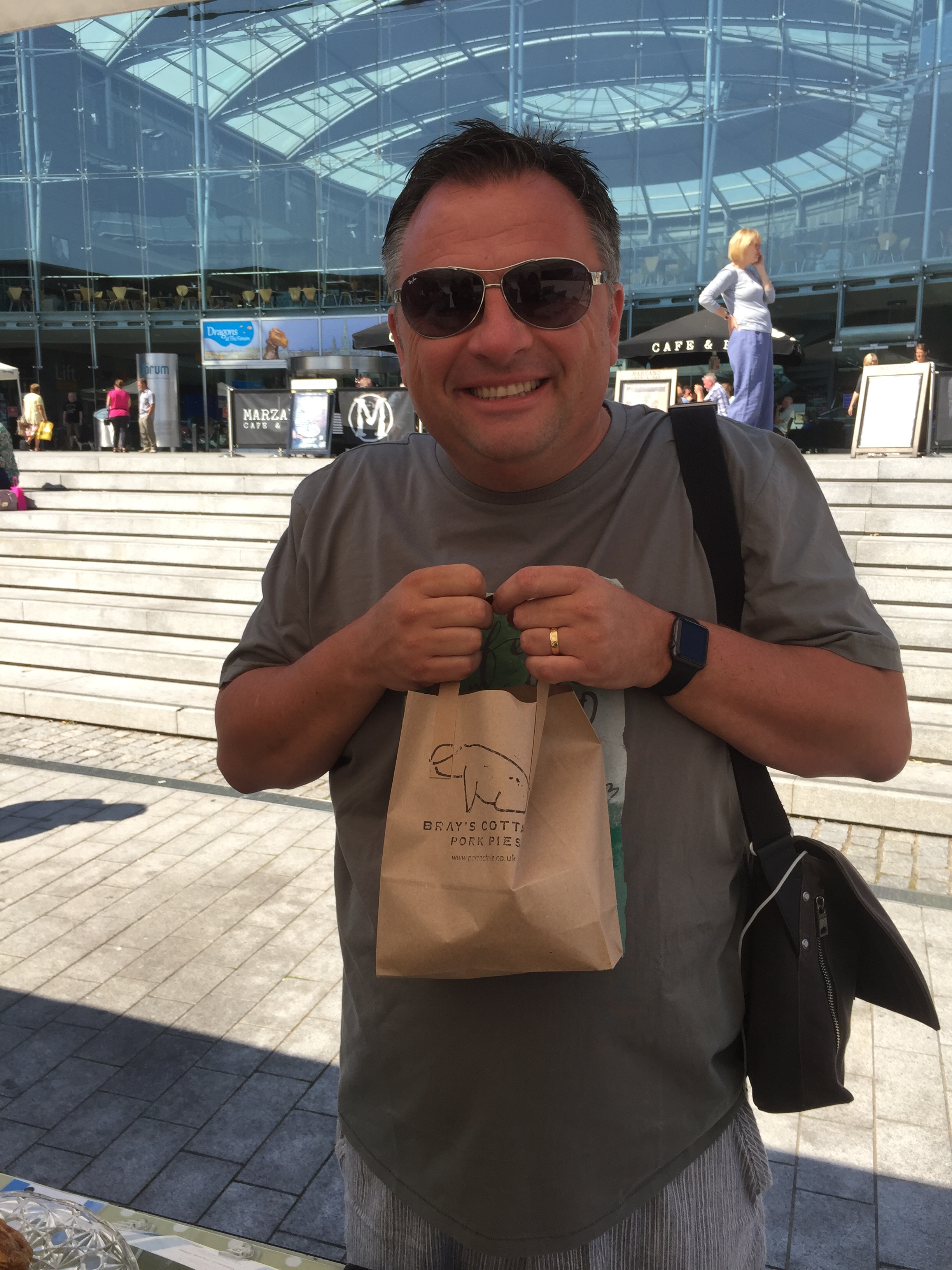 A happy customer clutching his pork pies