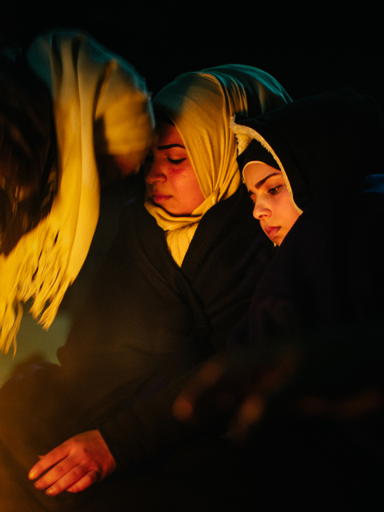 In a tender moment, a mother moves in and touches her head to her eldest daughter’s for reassurance as the girl begins to cry.