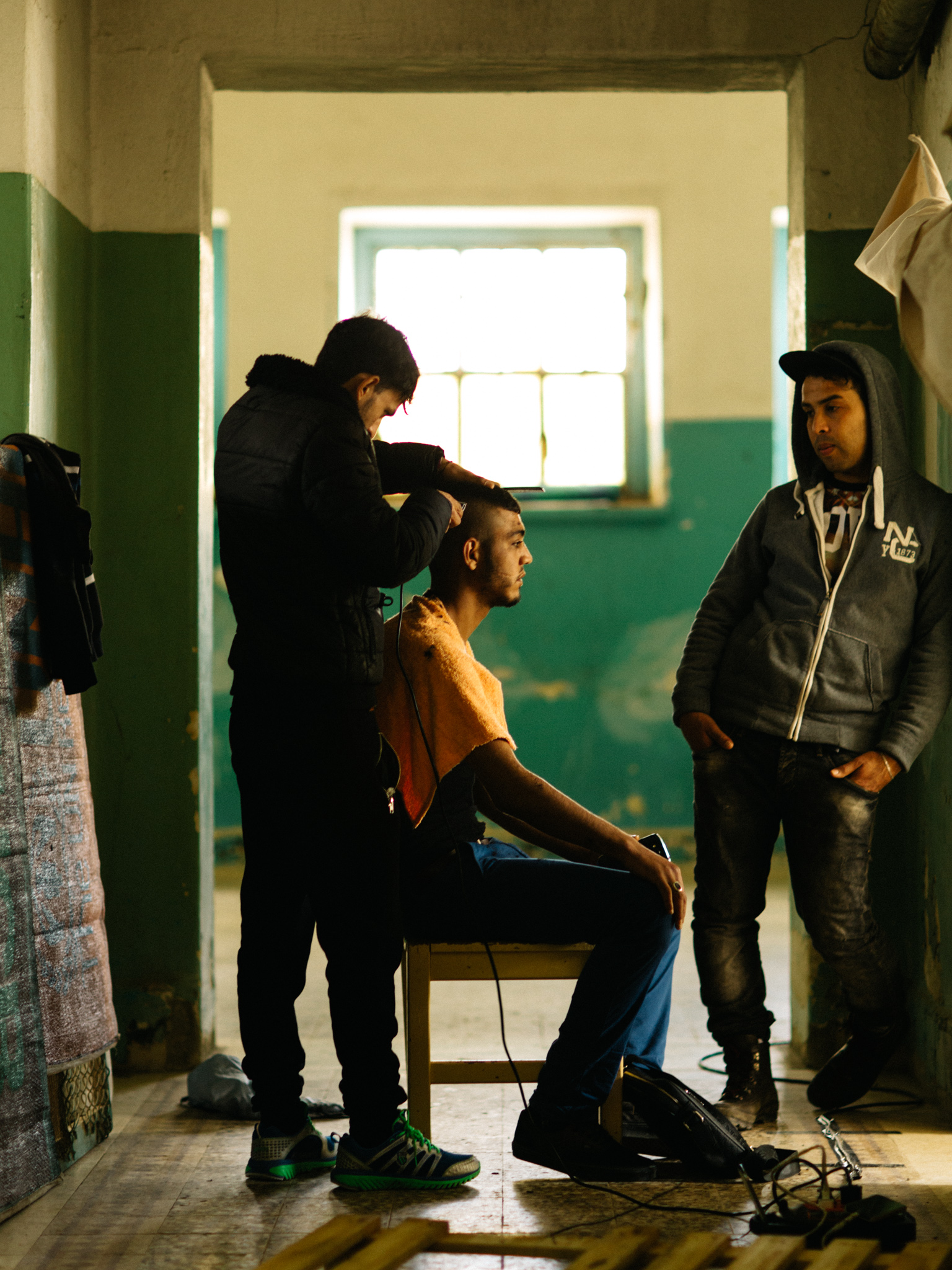 For many refugees caught in limbo, like these Algerians barred from traveling beyond Greece, it’s the mundane tasks that keep them sane. Like this man who offered to cut everyone’s hair on this sunny afternoon.