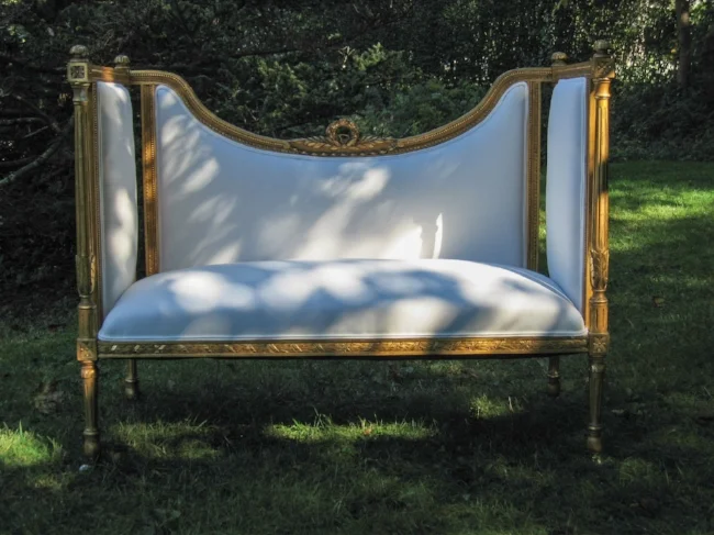 A golden framed settee re-upholstered in white for a fresh look.