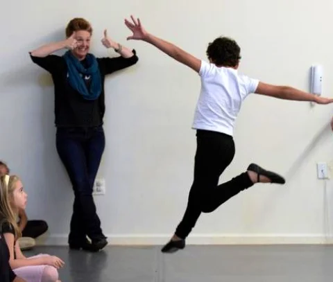 Artistic Director, Shannon Hummel, gives a thumbs up to a Ballet 1 student learning to leap!