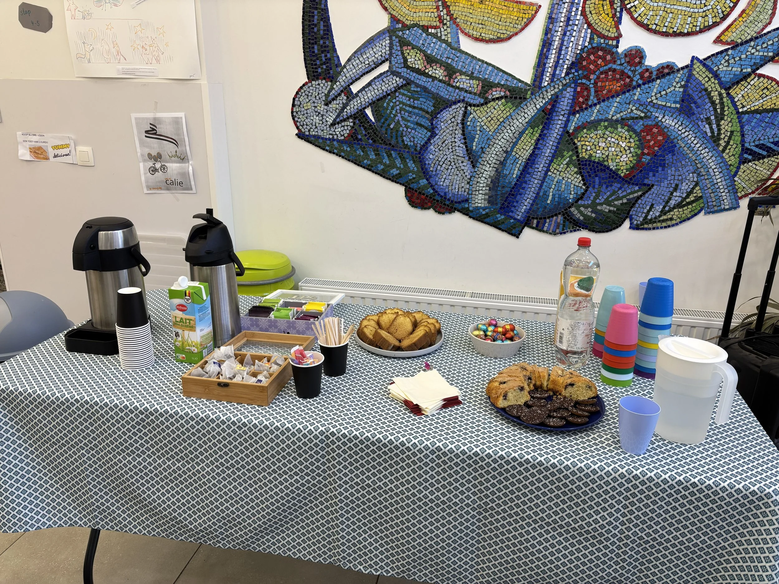 Table avec des cupcakes, biscuits, œufs en chocolat, et boissons pour le café après notre rassemblement