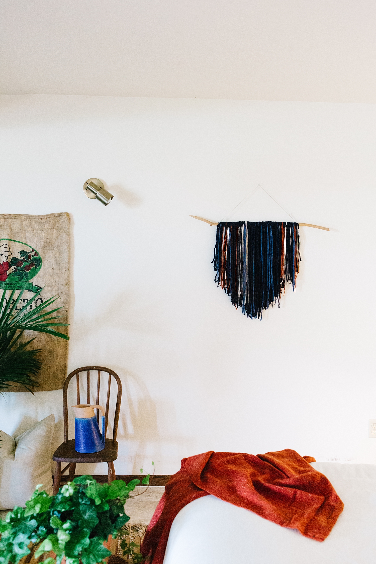 Notes of orange in the boho wall hanging are picked up from the burnt terracotta throw at the foot of the bed. I chose a dominant color of navy for the wall hanging, and sporadically inserted other colors of blue, orange, and beige to add depth and texture.