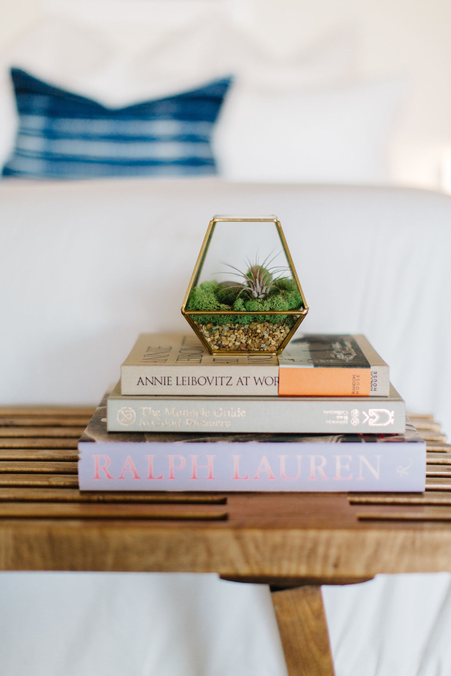 Symmetry continues to play a huge role in this space. Atop this teak bench found at an antique mall are some favorite books along with a miniature terrarium housing an air plant.