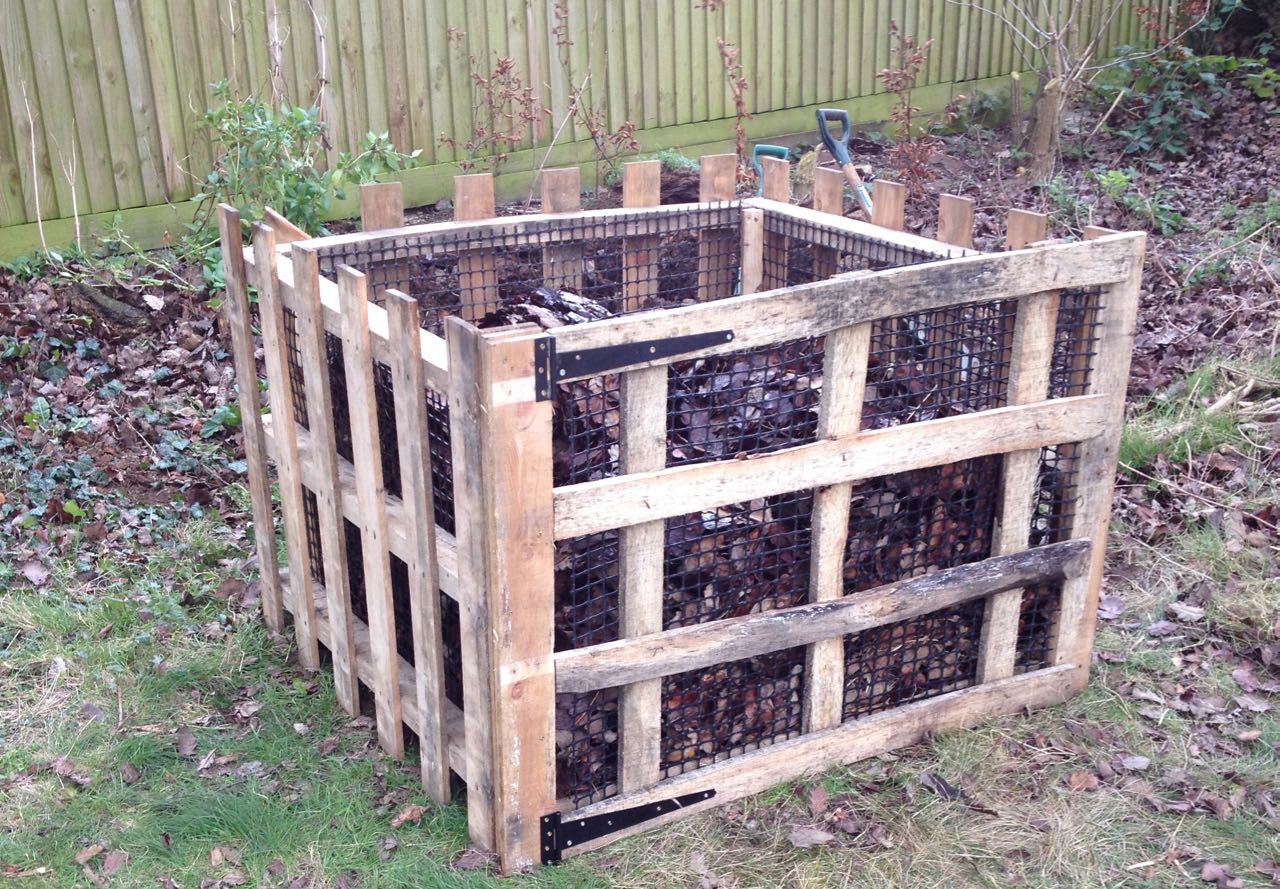 The finished leaf mould bin, which is in front of the previous one, well away from the trees and native hedge. It re-uses the old plastic mesh and four pallets that would otherwise have gone to waste.
