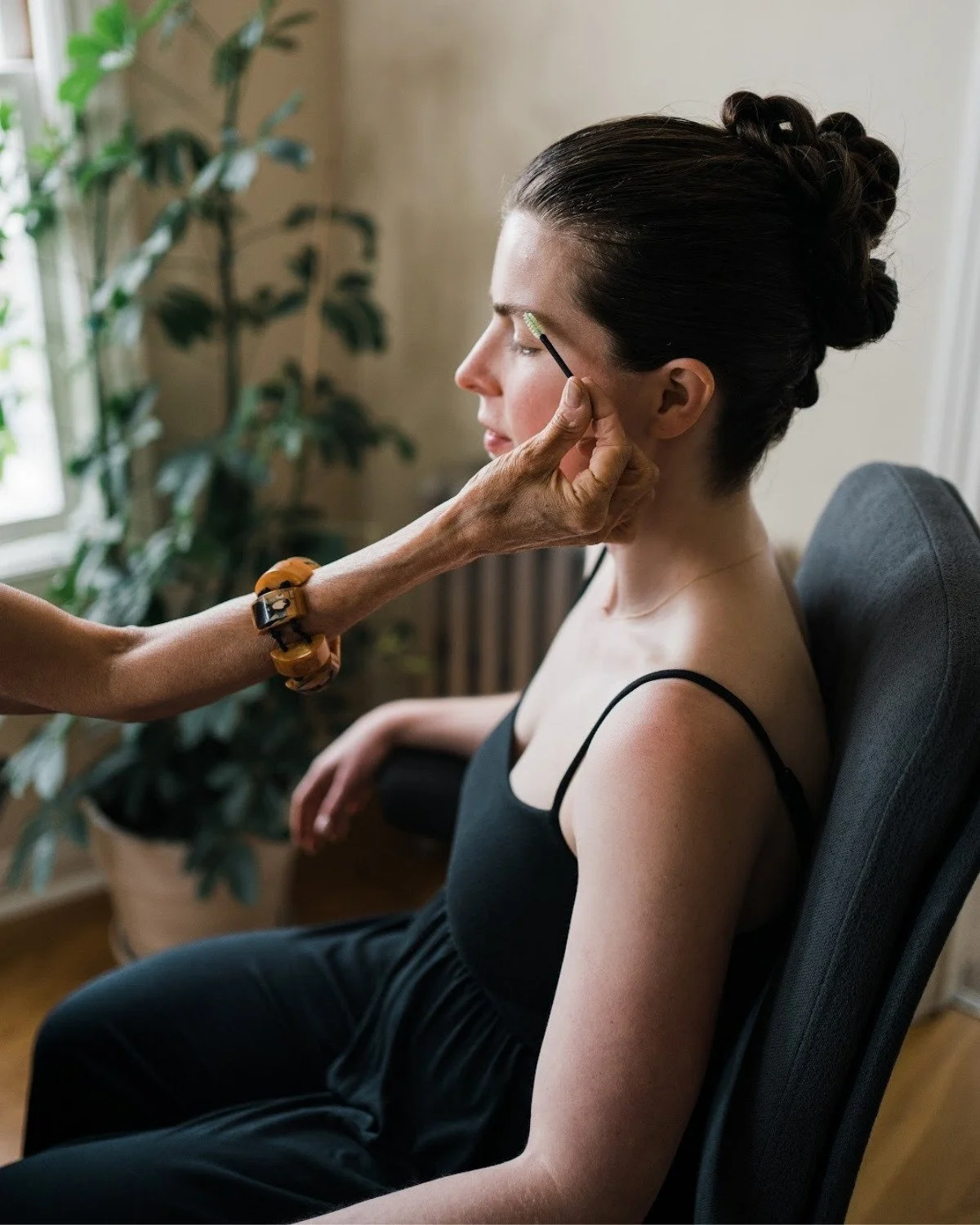 Behind the scenes of Rebecca applying makeup to a bride's face on her wedding day