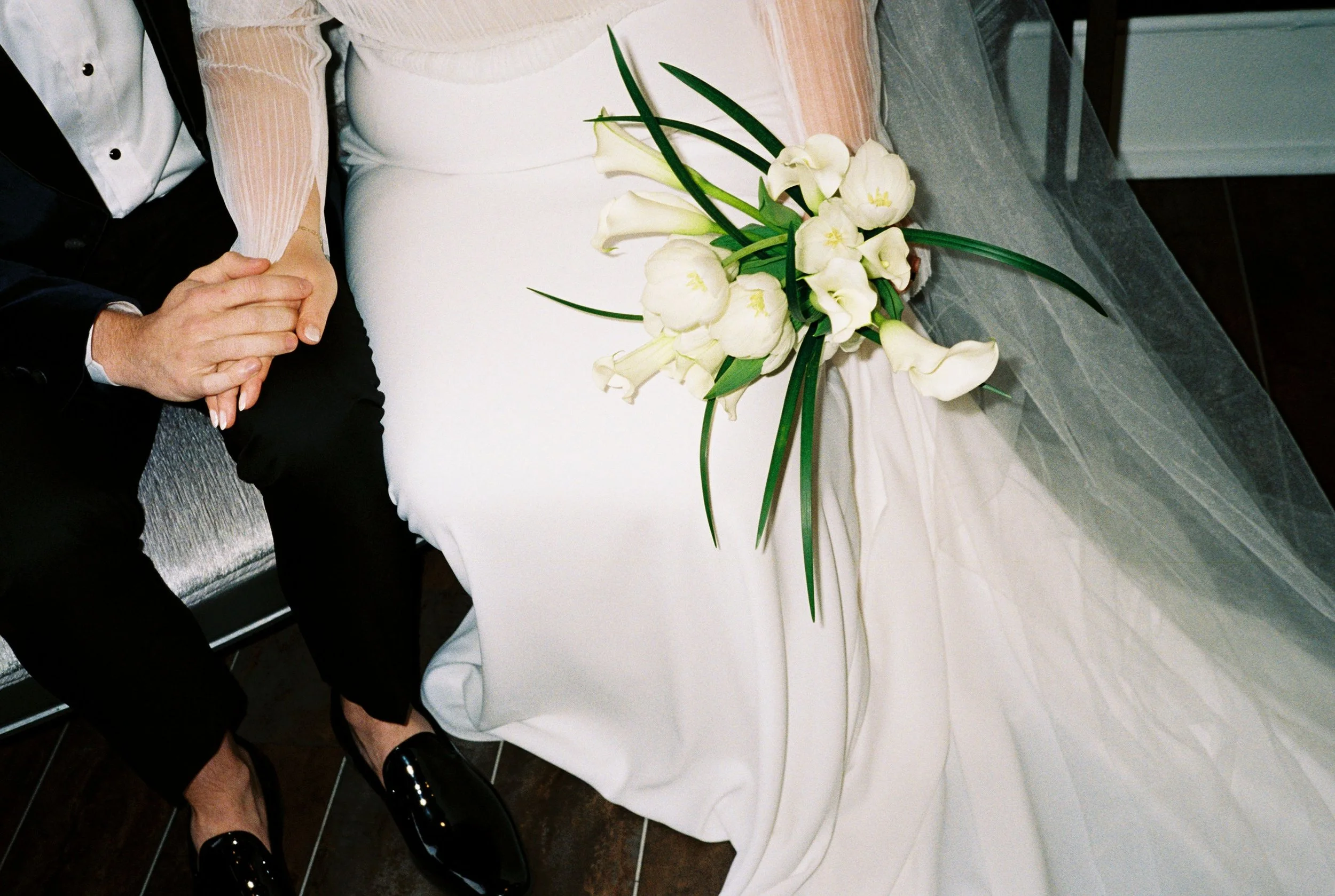 Detail of a bride and groom holding hands
