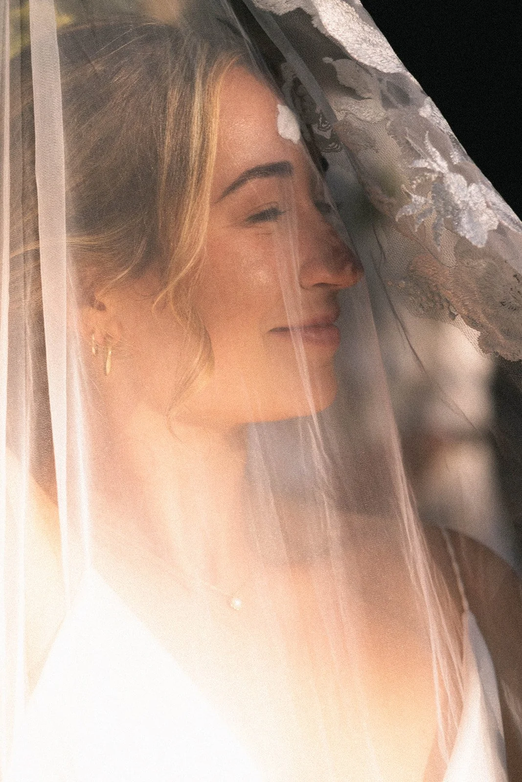 Bride in intimate wedding moment with calm, luminous bridal makeup and effortless hair styling.