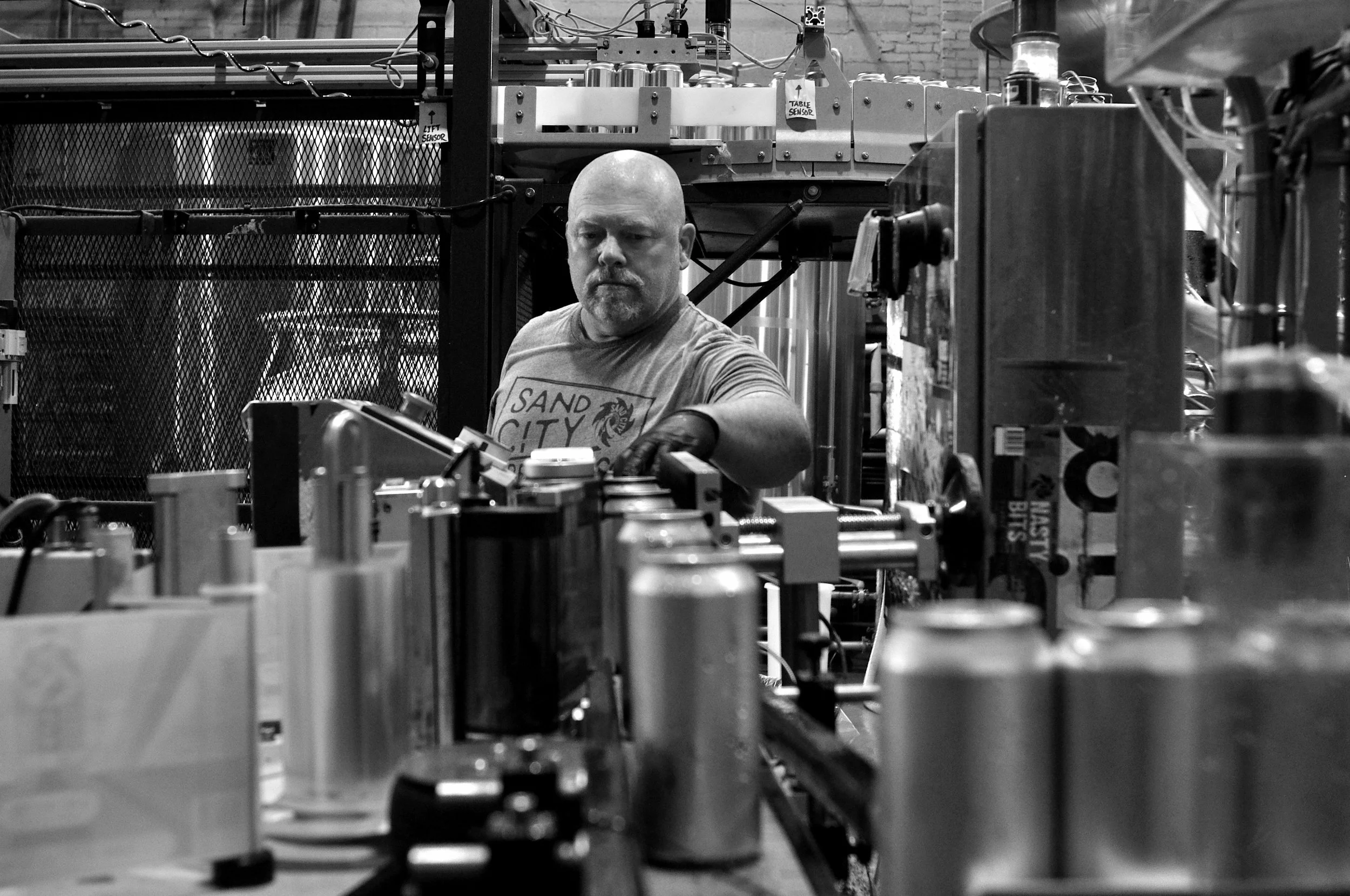 032.TOM PULLS THE SEALED CANS FROM THE CONVEYER BELT.jpg