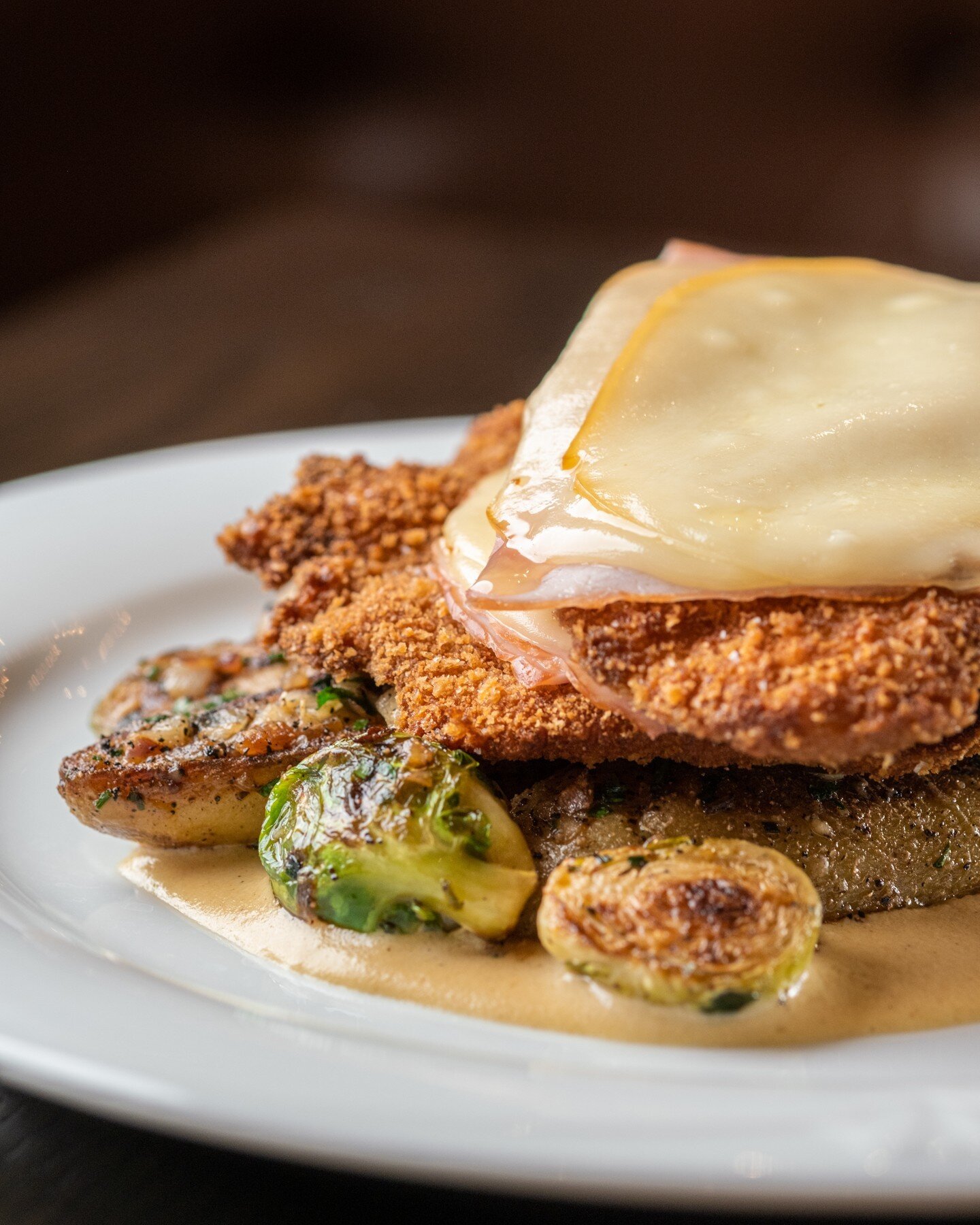 Hey foodies! Get ready to indulge in the ultimate comfort food experience with the Blackshop Schnitzel - a delicious dish featuring Black Forest Ham, Smoked Provolone, Fingerling Potatoes, Brussel Sprouts, and Dijon Cream. This perfectly balanced mea