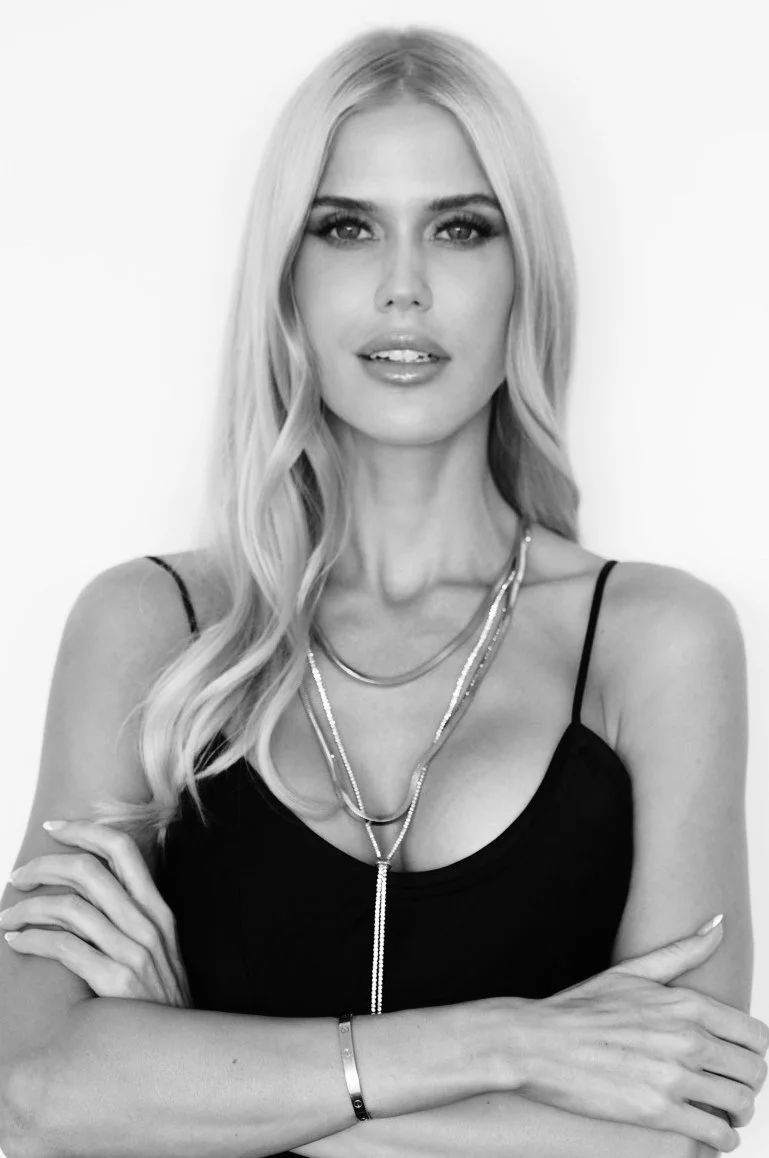 Image of Georgia Sinclair, Founder, Loaded Dice | Licensed California Real Estate Professional | International DJ, Podcast Host and Keynote Speaker. This image is black and white and Georgia is crossing her arms.