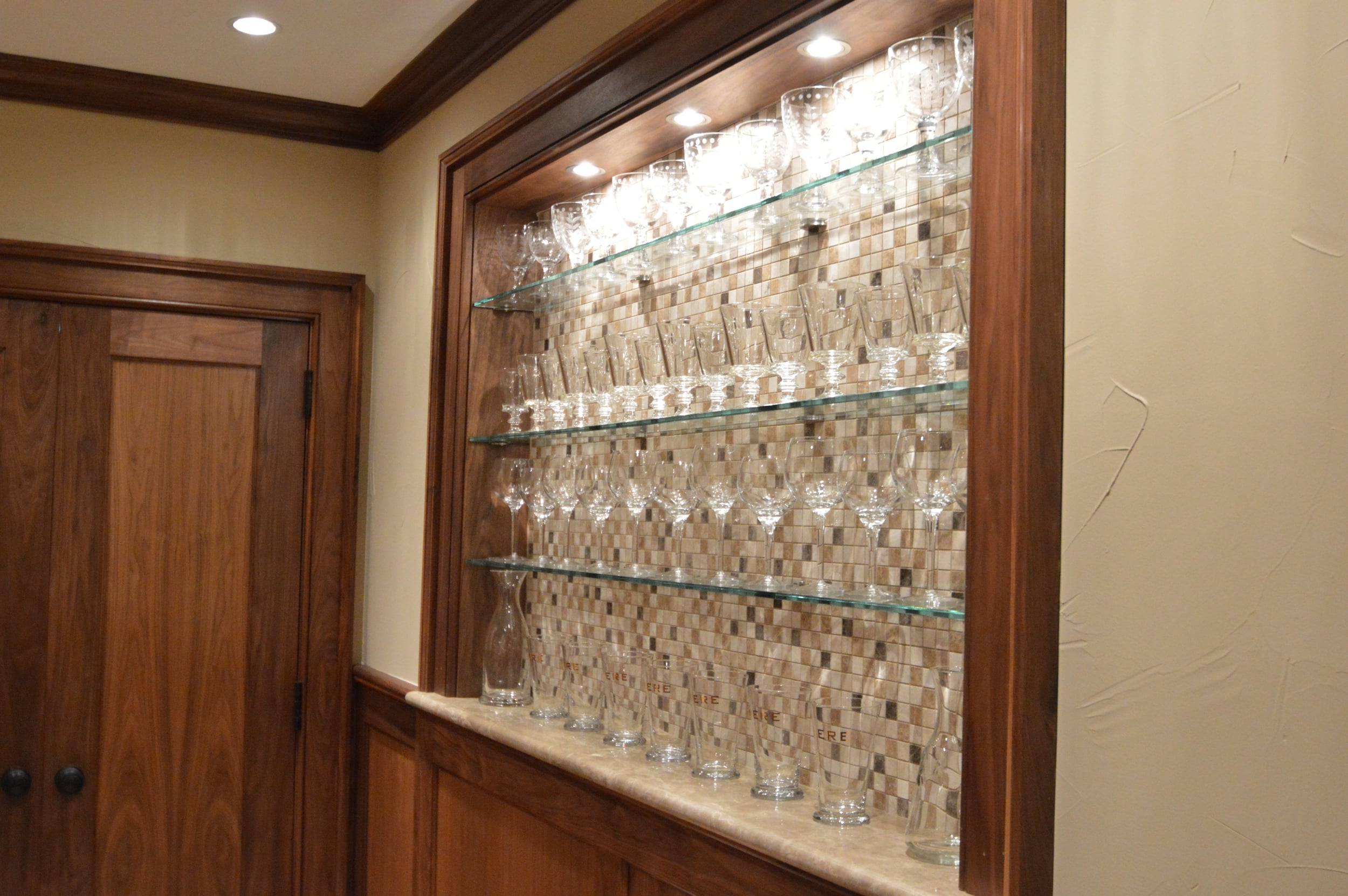 Custom bar shelving outside a wine room.