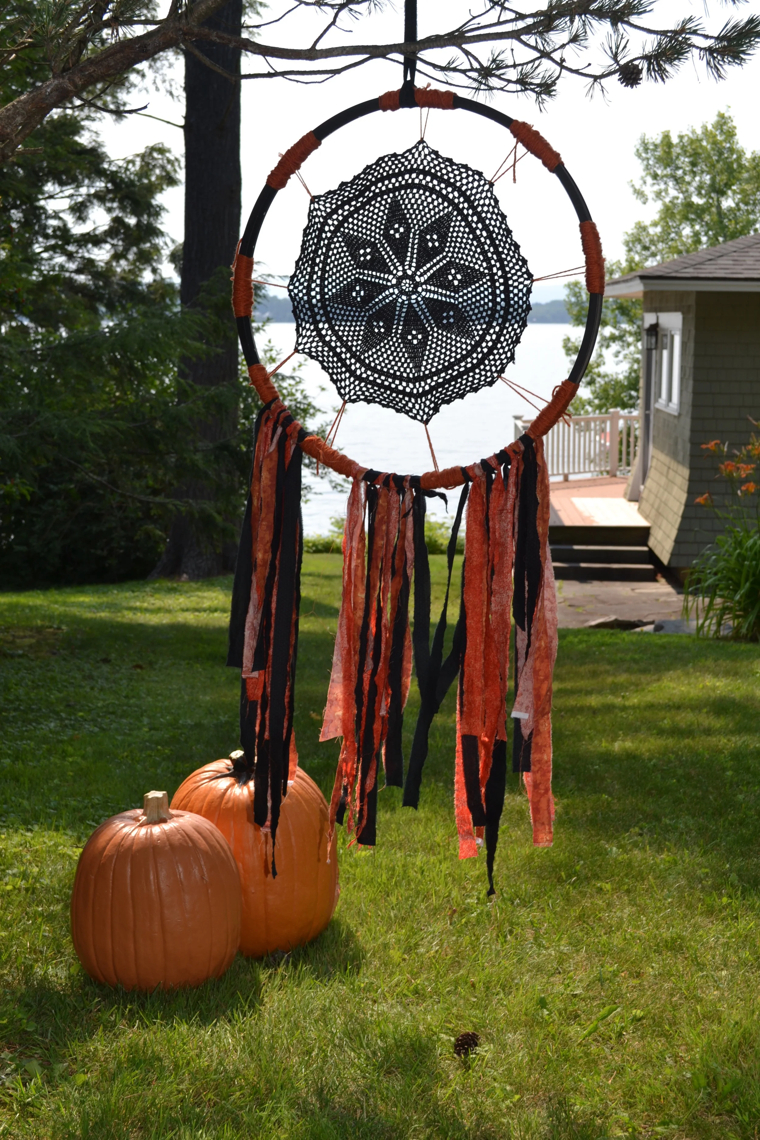 I call this my nightmare catcher. You can make them from an old bicycle tire rim, a vintage dollie painted black, some yarn and scraps of fabric. Hang them in the trees around the house, great for a Halloween party.