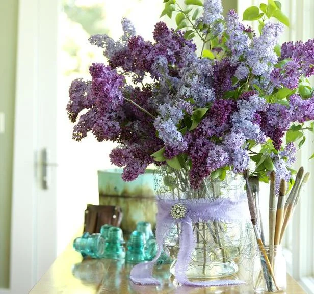 LAST BUT NOT LEAST — STILL ONE OF MY FAVORITE PICTURES… DIY VASES — This second hand glass vase was wrapped in chicken wire, a purple ribbon and a vintage brooch. I LOVE LILACS!