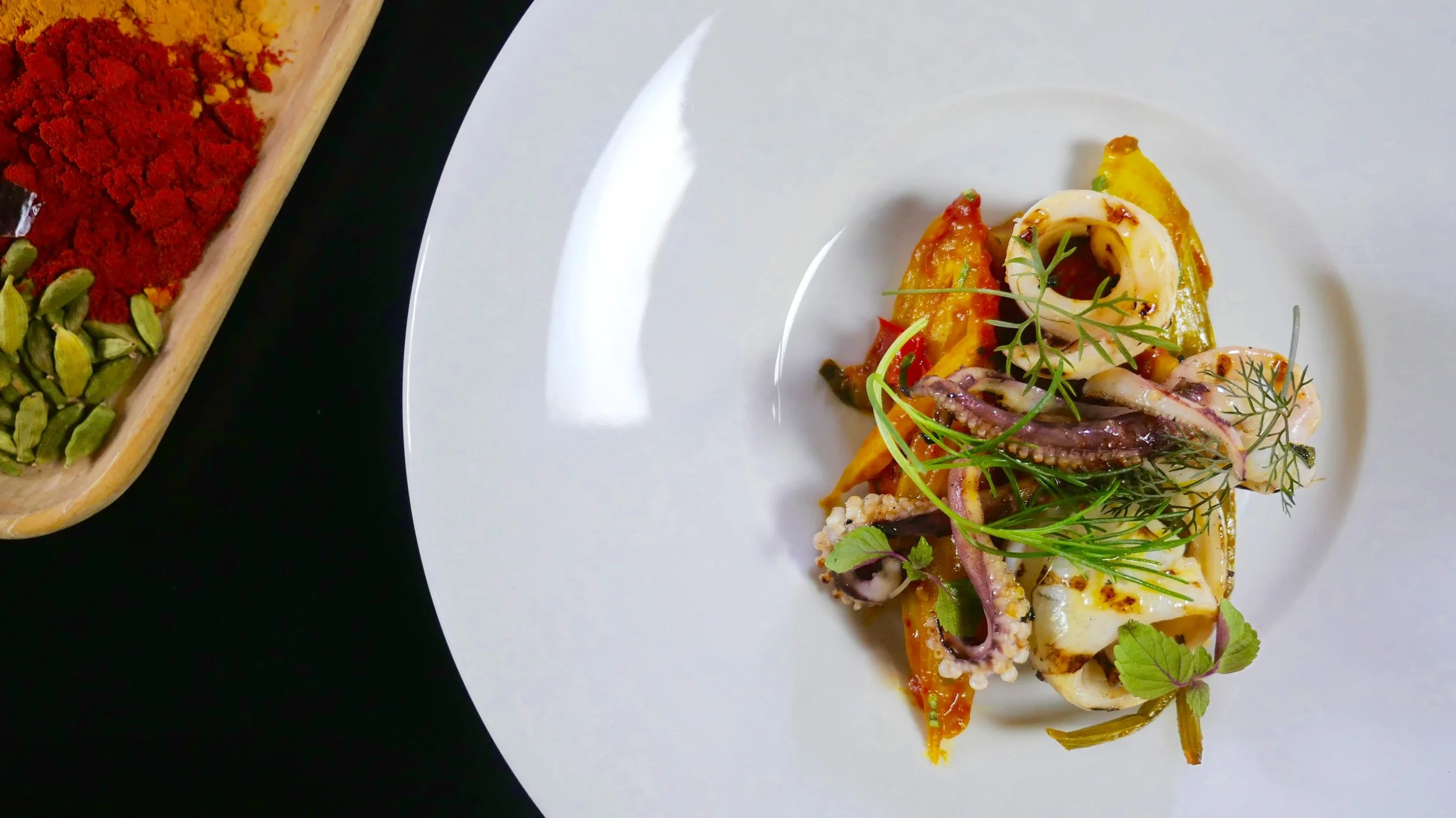 GRILLED SOUTHERN CALAMARI, BABY FENNEL, GREEN MANGO, FENUGREEK & TANGA SAUCE. 