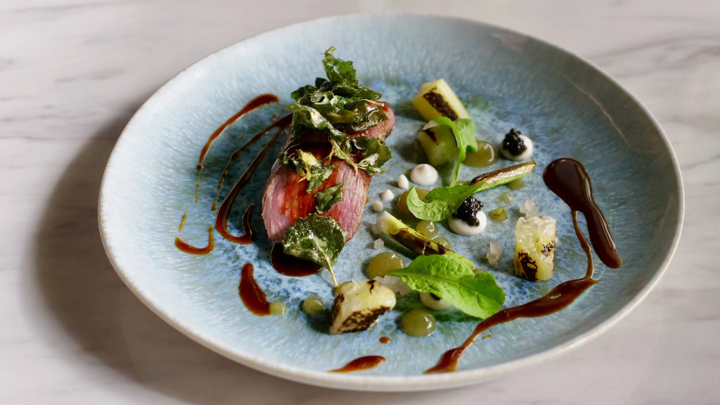 LACHLAN VALLEY LAMB, FRIED SALTBUSH, CHARRED CUCUMBER SAUCE, PETITE BOUCHE ROCKET.
