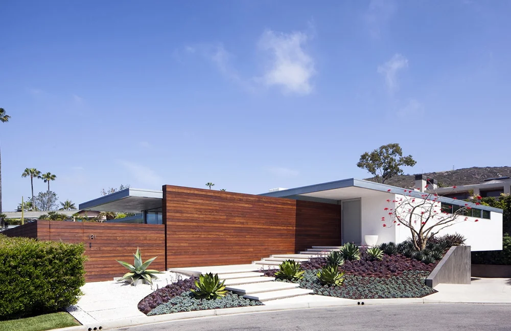 Entry along ipe wood wall leading to front door