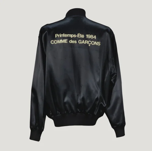 killheji:

Comme des Garçons 1984

 BLACK SATIN JACKET EMBROIDERED WITH THE NAME OF THE COLLECTION, WORN BY THE STAFF WORKING ON THE SHOW