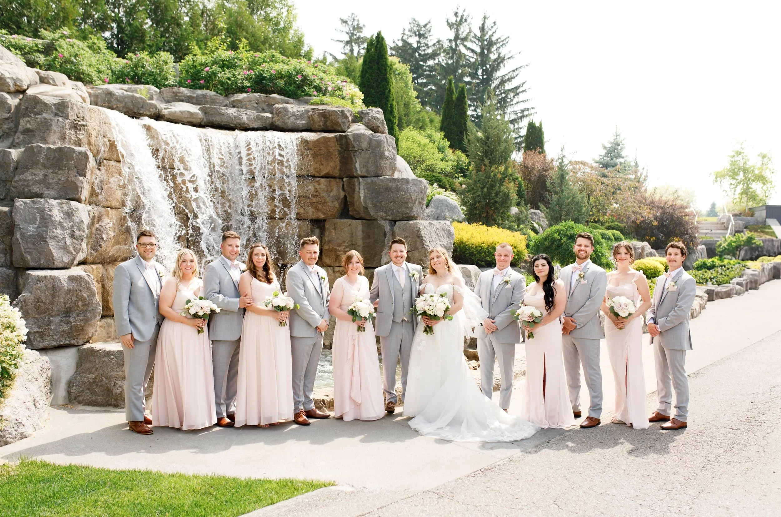 Wedding party portrait beside waterfall feature at Whistle Bear Golf Club in Cambridge, Ontario