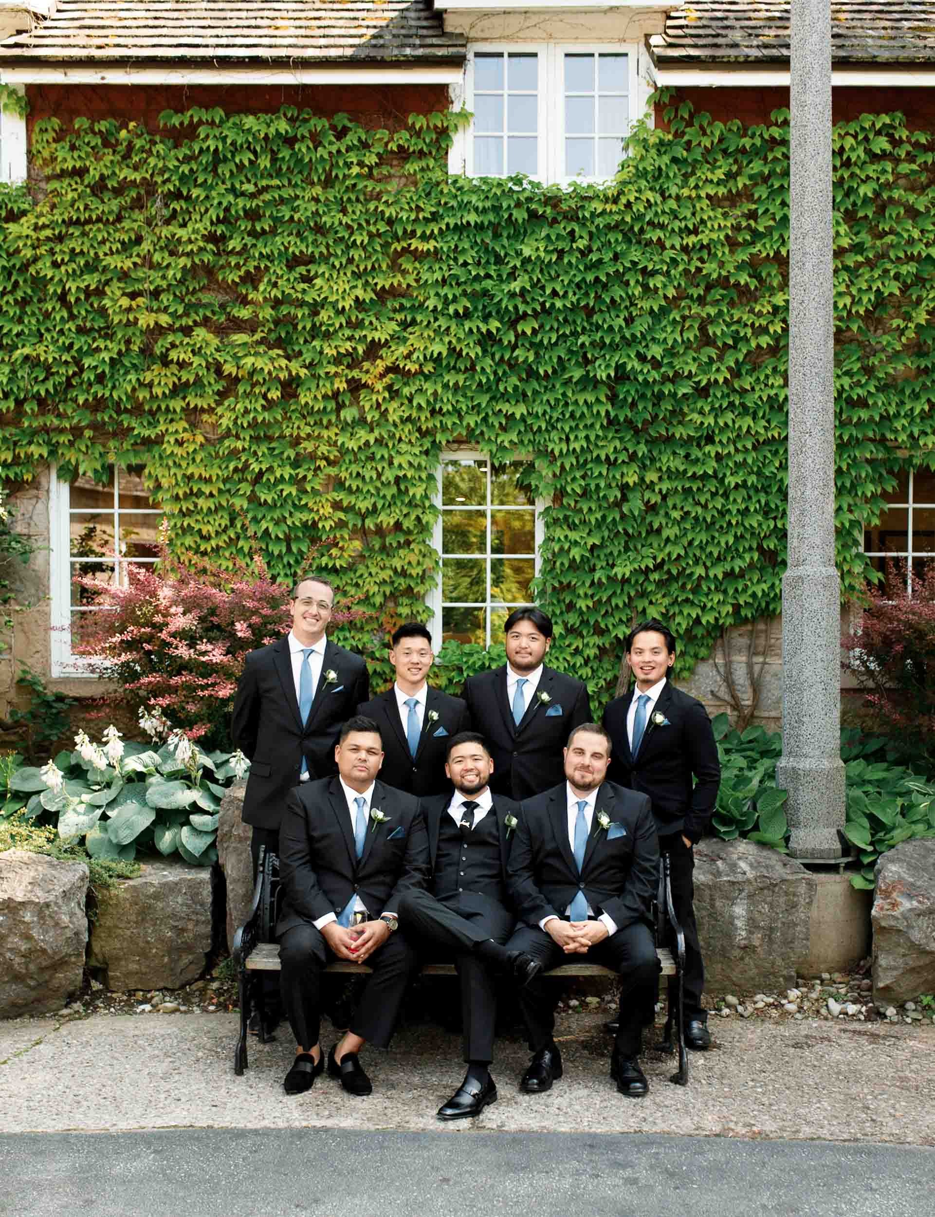 Groomsmen portrait in front of the ivy-covered Ancaster Mill exterior