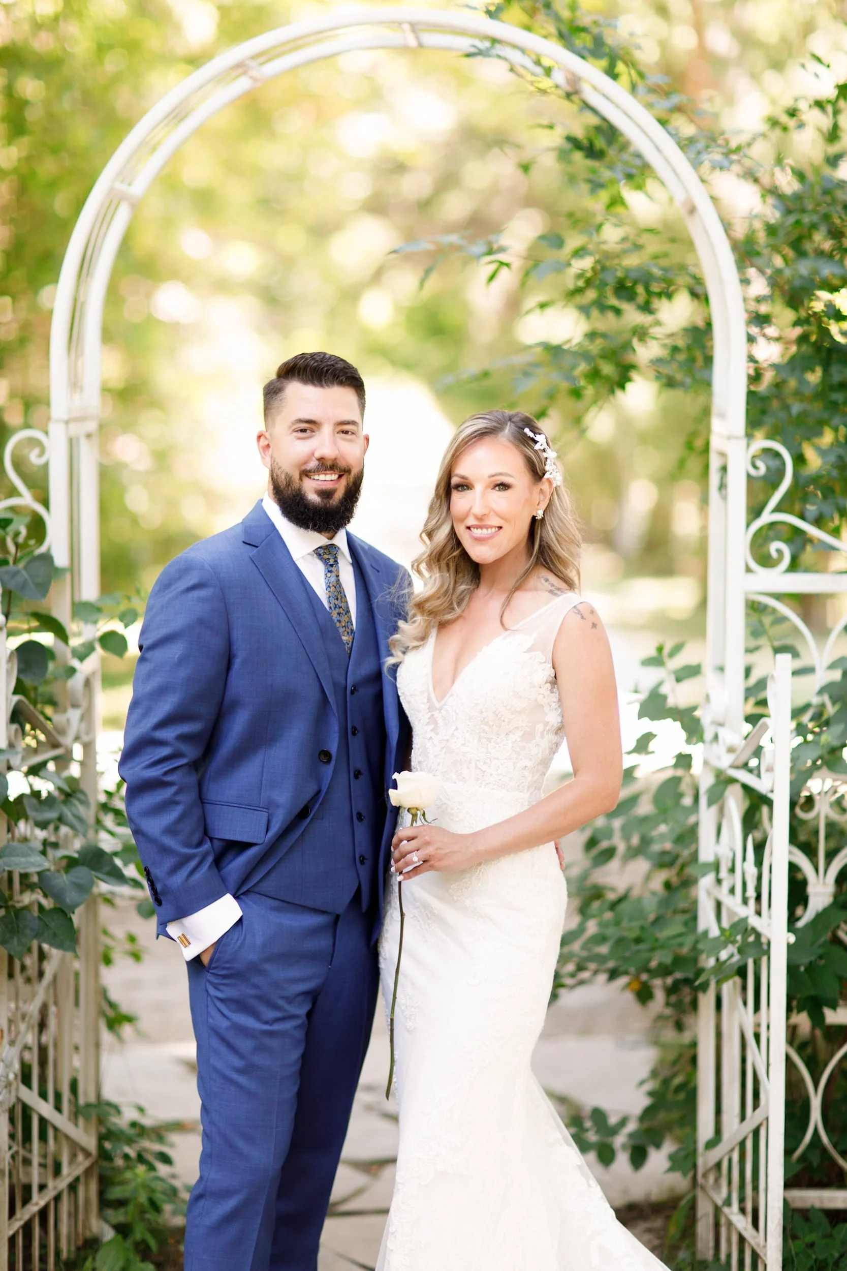 Bride and groom portrait beneath garden arch at Kurtz Orchards