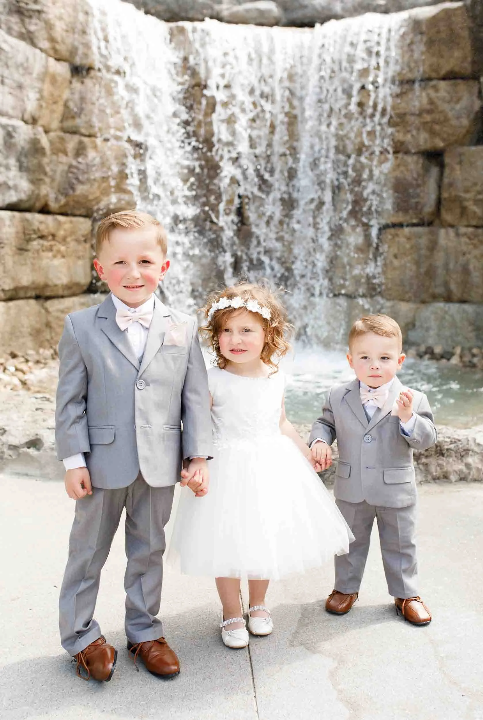 Flower girl and ring bearers in front of waterfall at Whistle Bear Golf Club wedding in Cambridge, Ontario