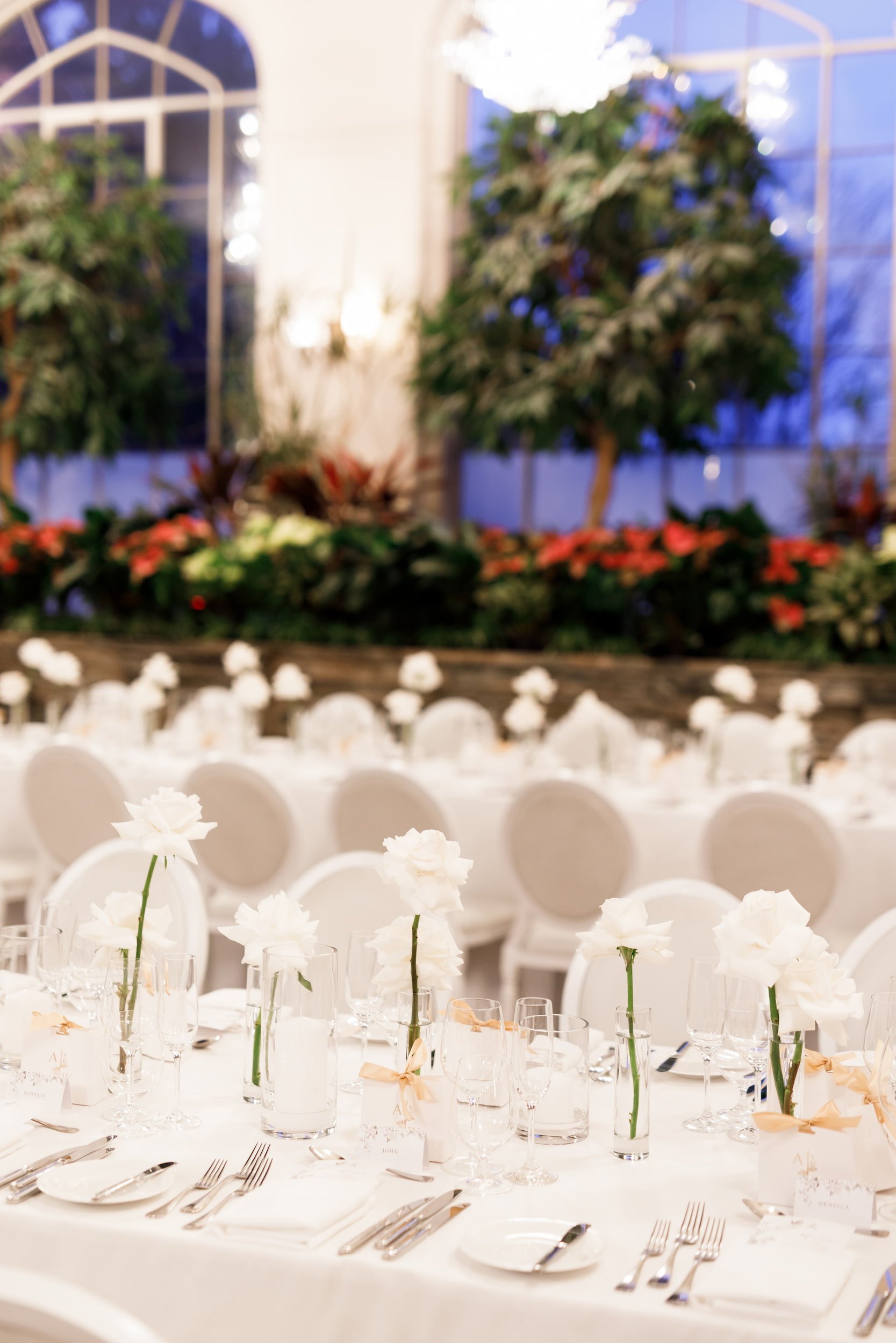 Floral reception setup beneath the stained glass dome in Casa Loma Conservatory