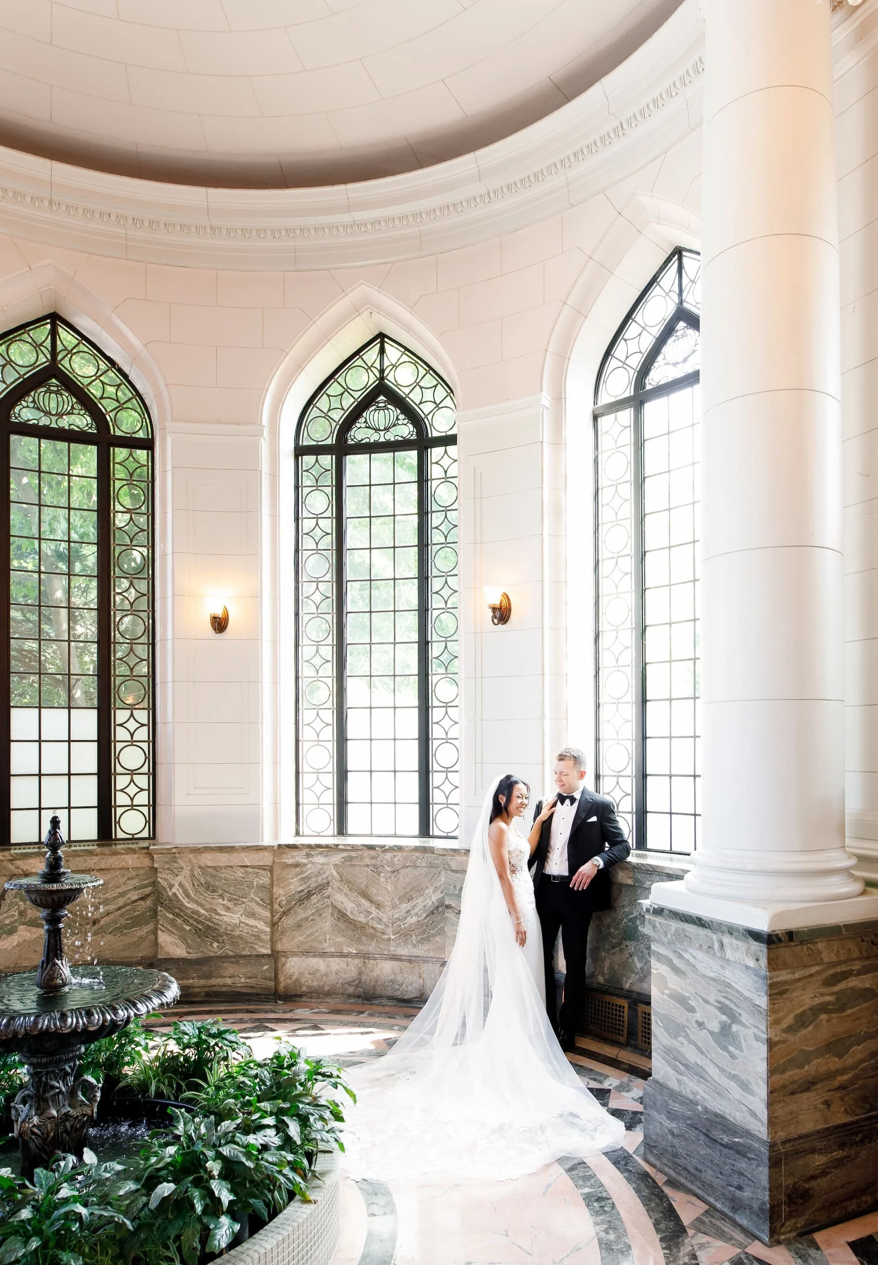 Bride and groom portrait beneath stained glass ceiling in the Casa Loma Conservatory