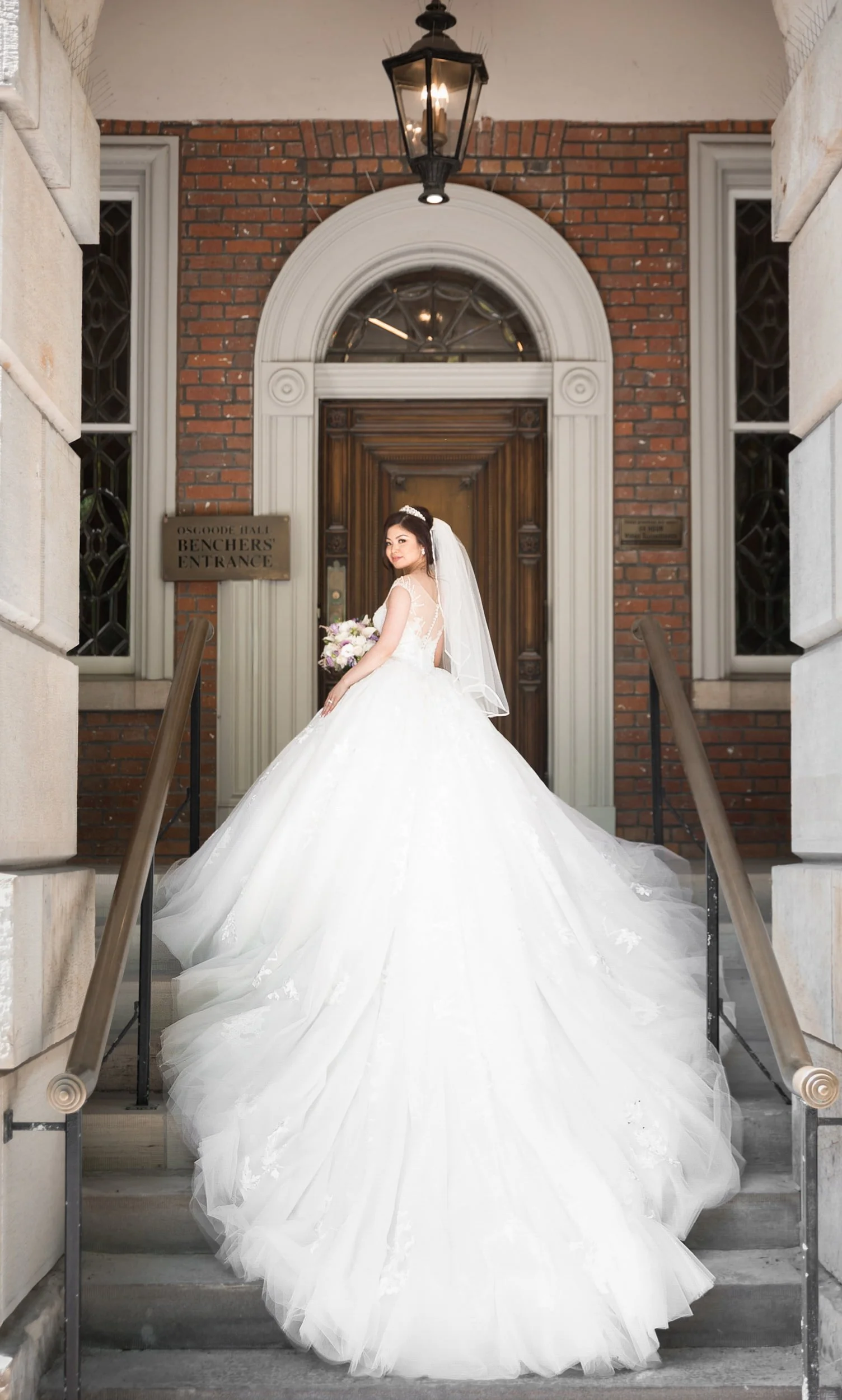 Bride entering historic doorway at Osgoode Hall in Toronto, Ontario
