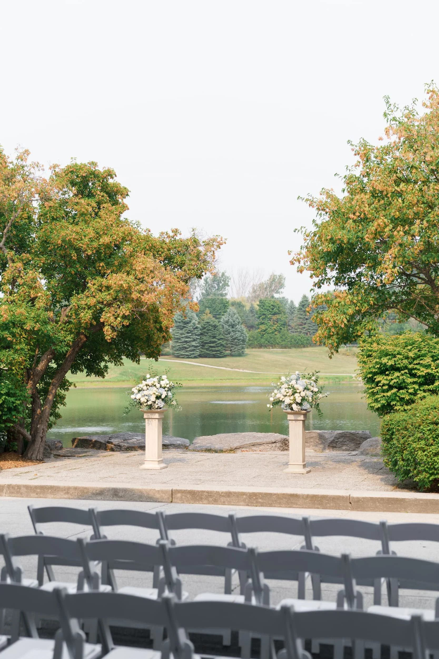 Lakeside ceremony space framed by trees at The Manor Event Venue wedding in King, Ontario