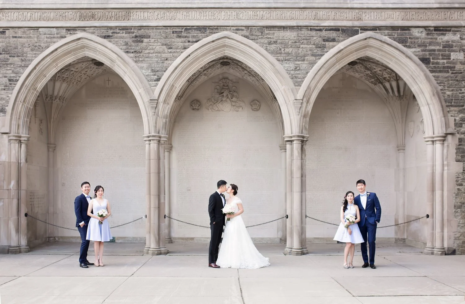 Wedding portrait framed by cloister arches at Knox College, University of Toronto in Toronto, Ontario