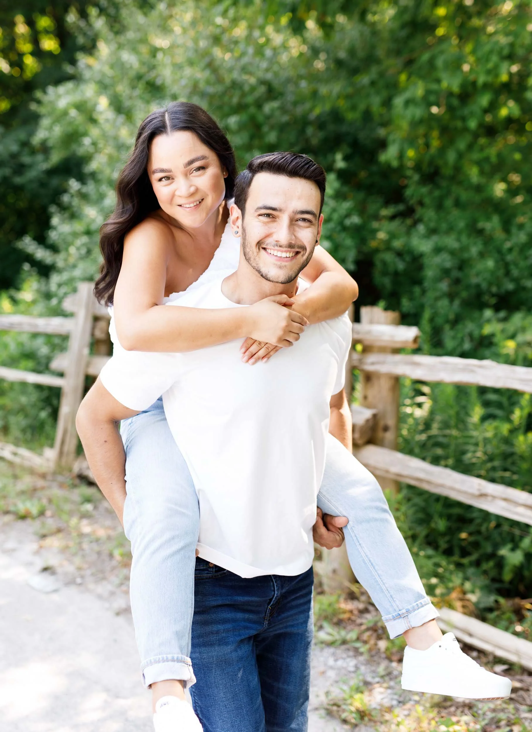 Bride to be laughing on her fiancé’s back during their engagement photos at Kortright Centre for Conservation in Woodbridge