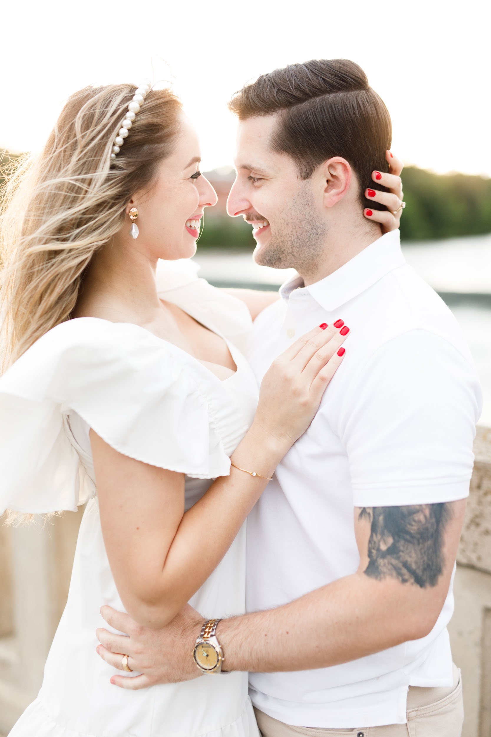 Windy romantic portrait of an engaged couple smiling at each other during their Mill Race Park engagement session in Cambridge