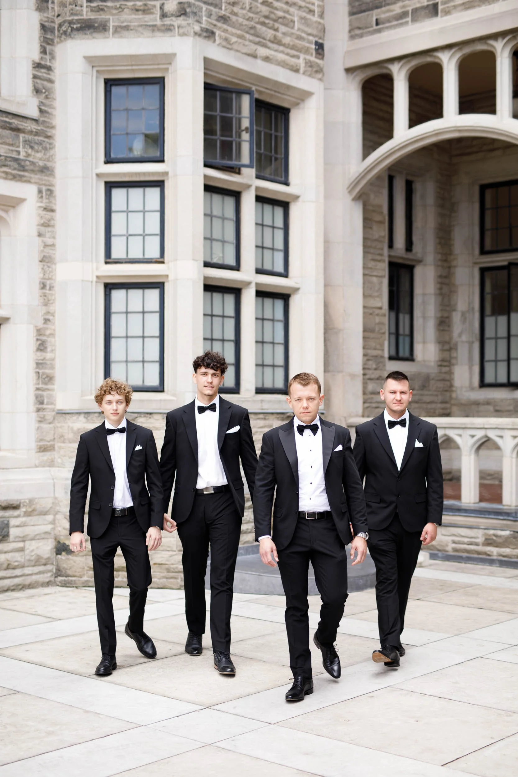 Groomsmen walking outside Casa Loma in Toronto