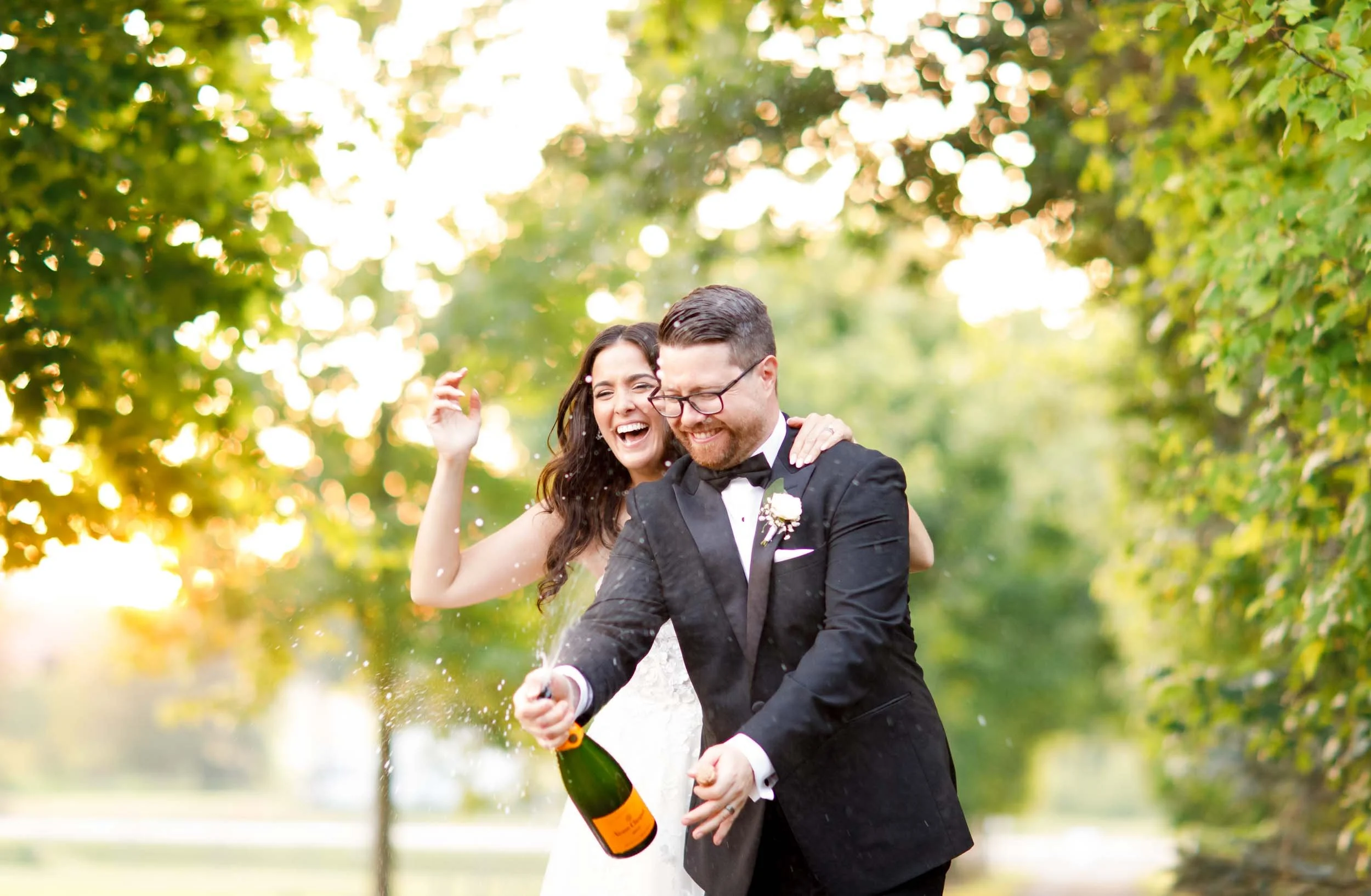 Bride and groom celebrating with champagne at a Cambium Farms wedding in Alton, Ontario