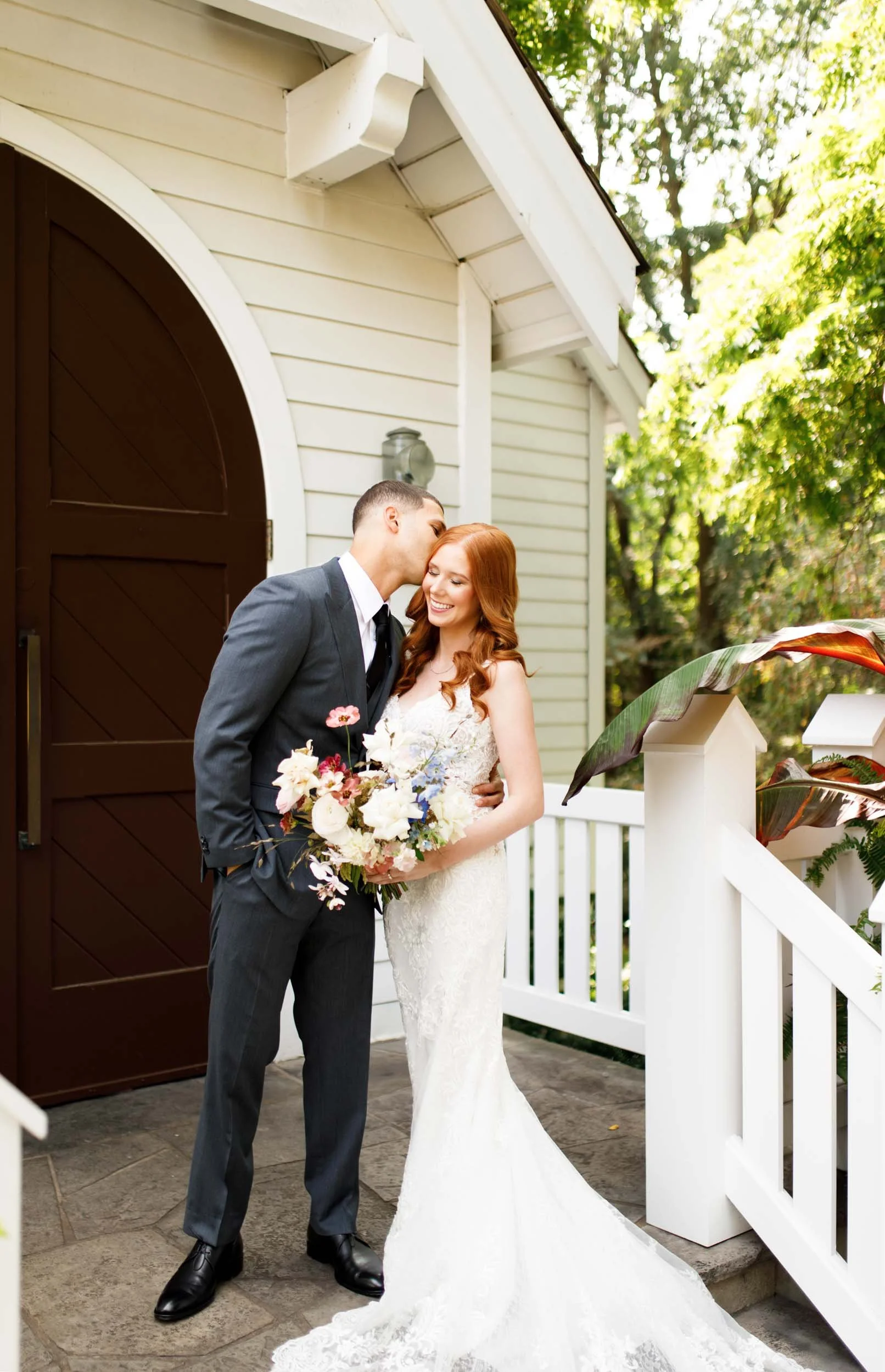 Bride and groom embracing on porch at The Doctor’s House in Kleinburg, Ontario