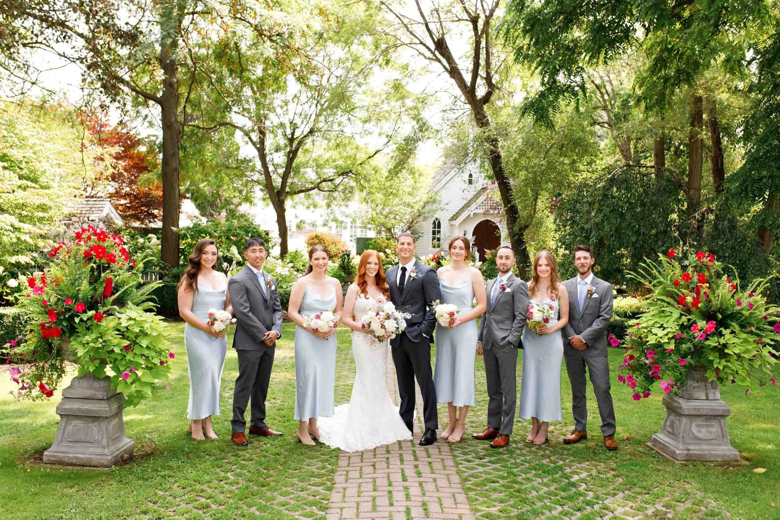 Bridal party standing in garden at The Doctor’s House in Kleinburg