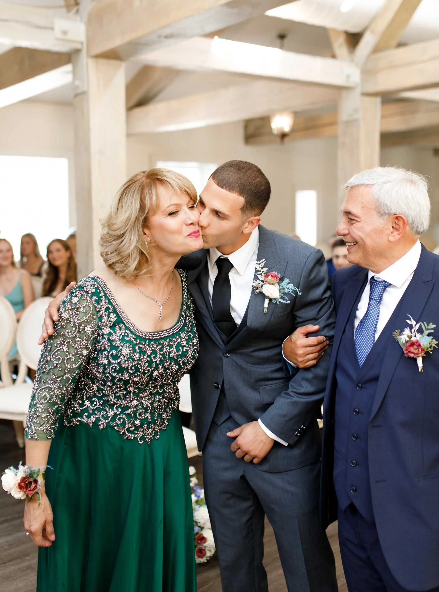 Groom walking with parents during ceremony at The Doctor’s House in Kleinburg
