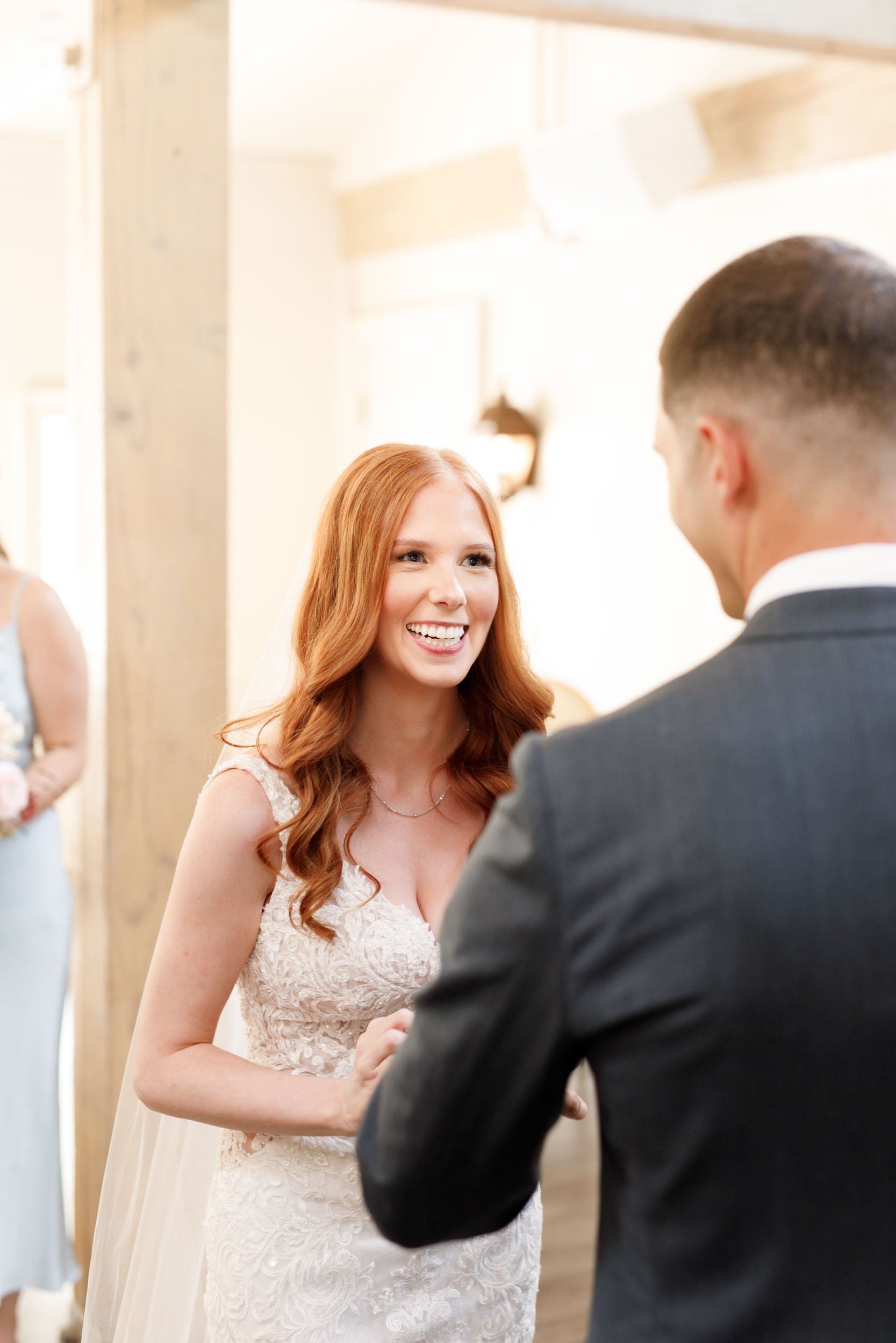 Bride smiling at groom during ceremony at The Doctor’s House in Kleinburg